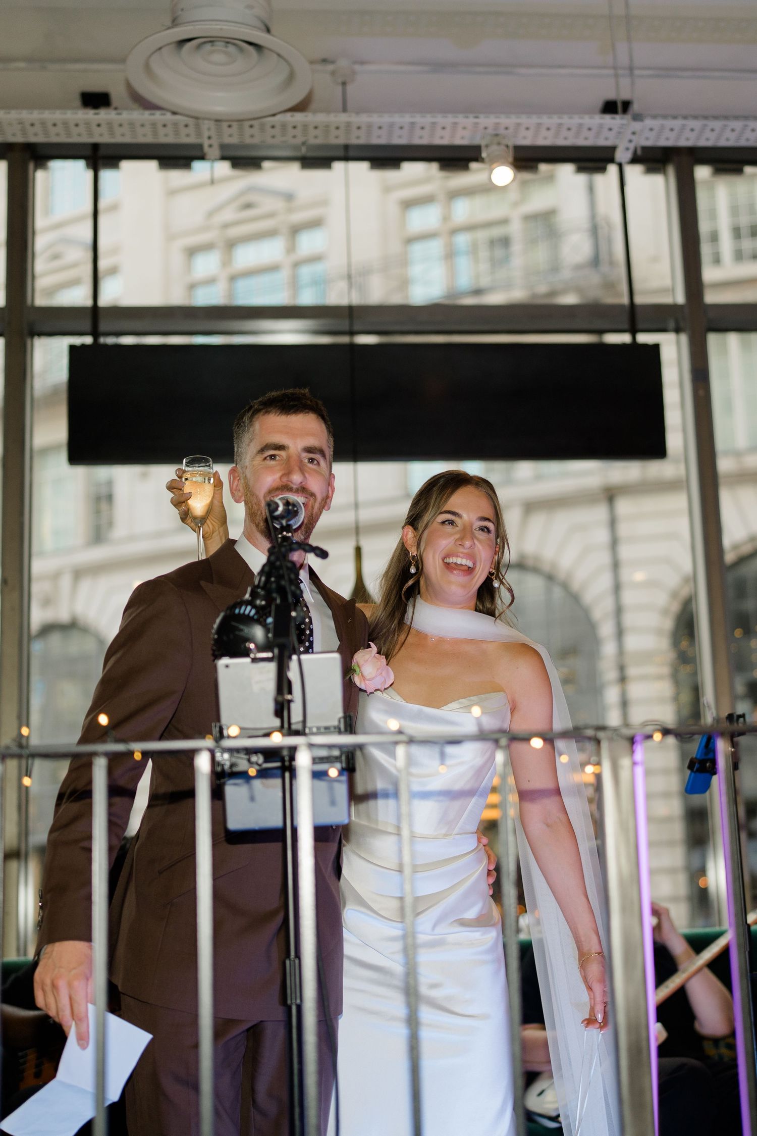 Bride and groom giving speech at wedding reception venue.
