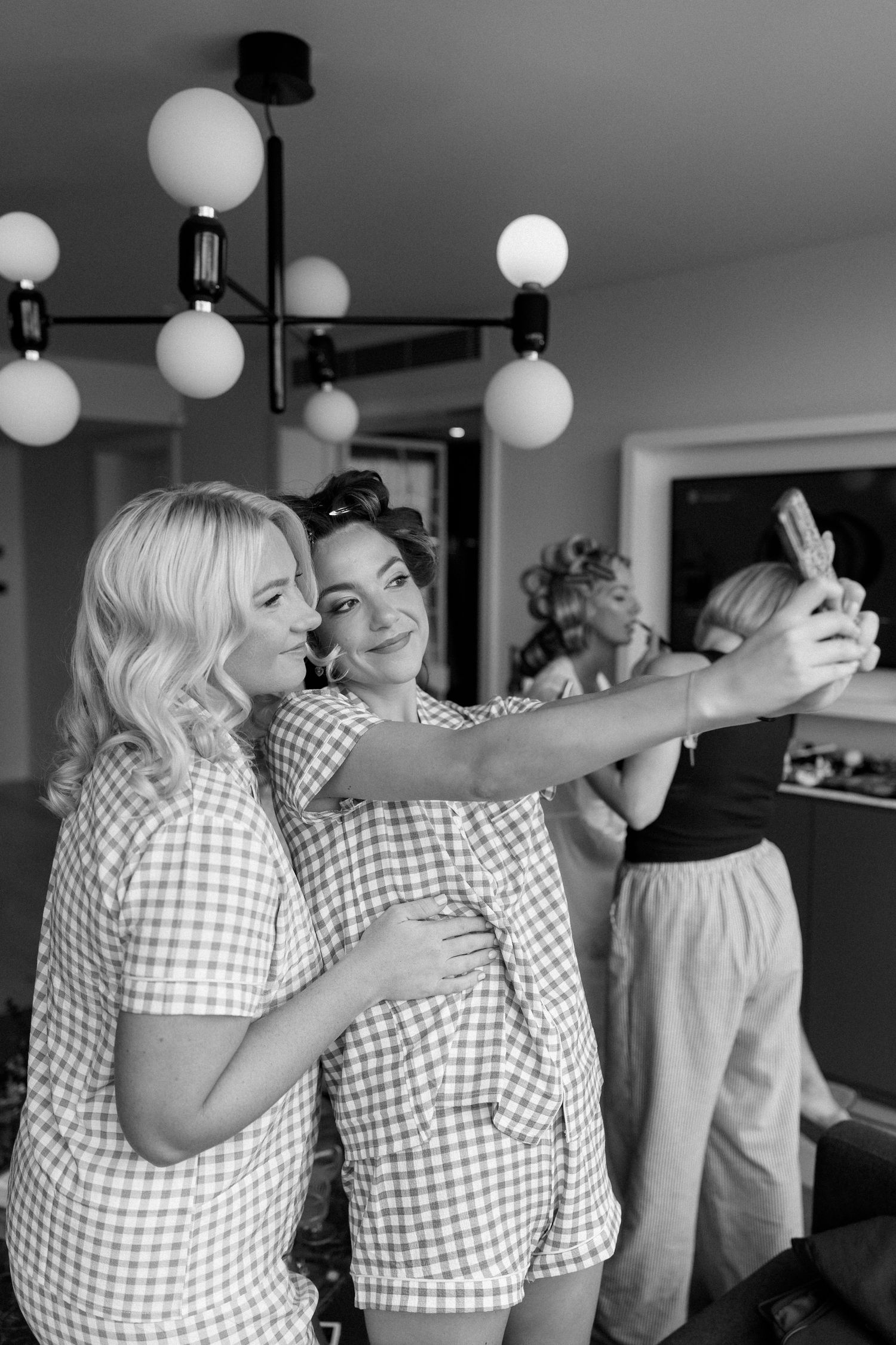 Group wearing matching gingham pattern shirts celebrating together under round pendant lights.