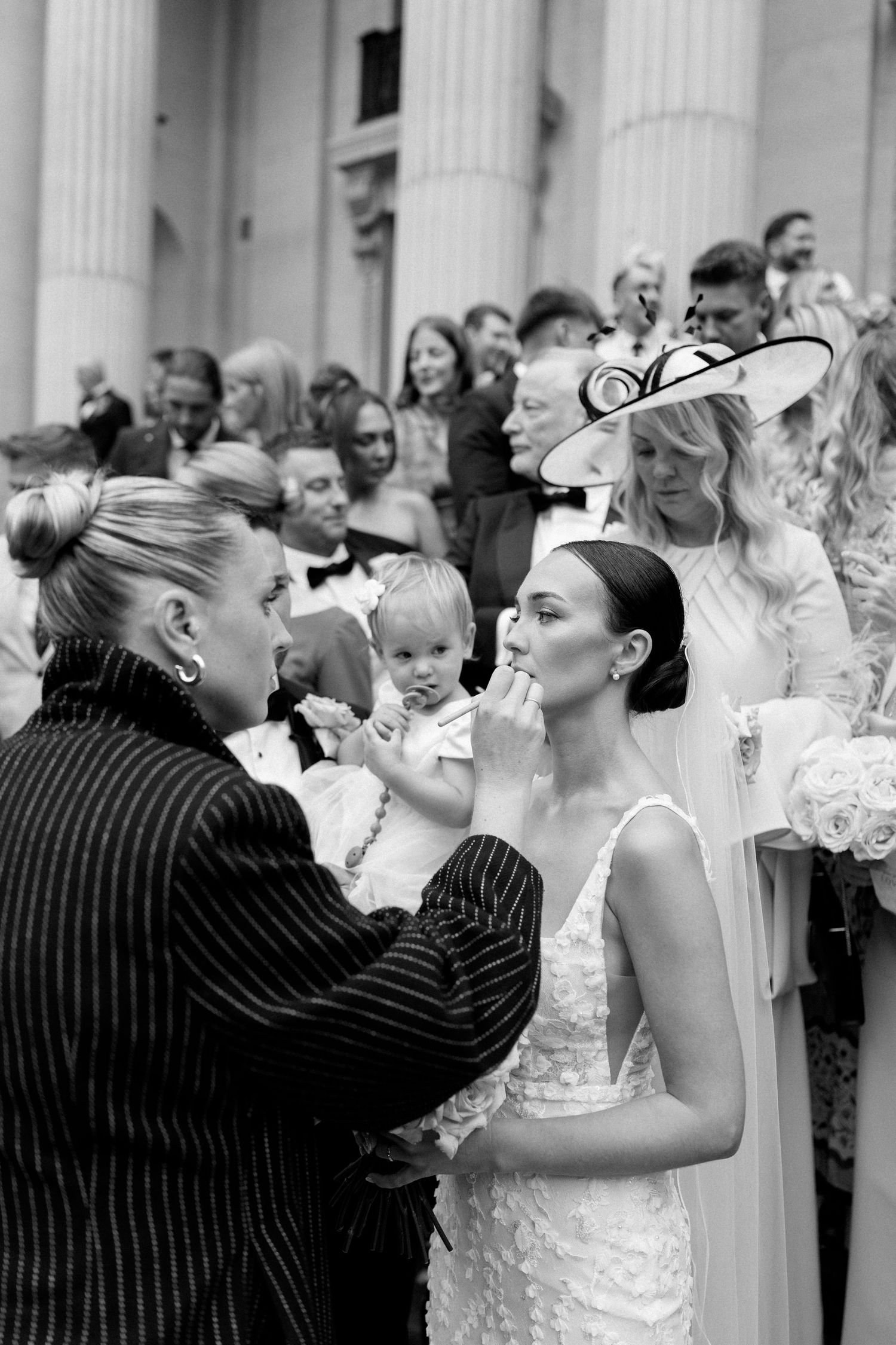 Black and white sequence showing a fun wedding moment with a couple dancing outside a columned building.