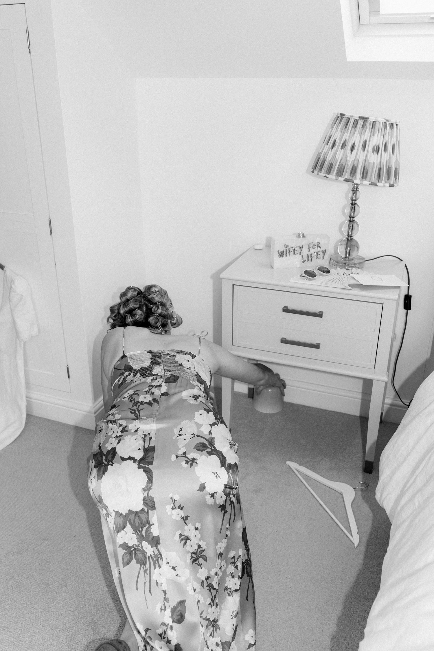 Floral patterned chair and white furniture in bright bedroom setting.