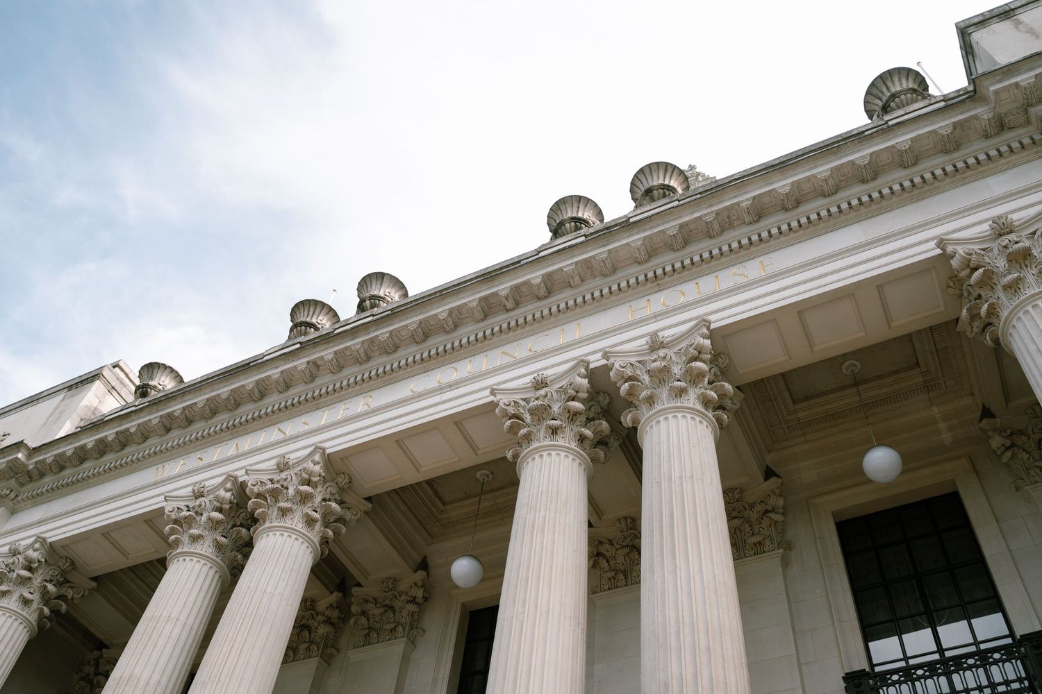 Architectural detail of classical building with Corinthian columns and ornate cornice.