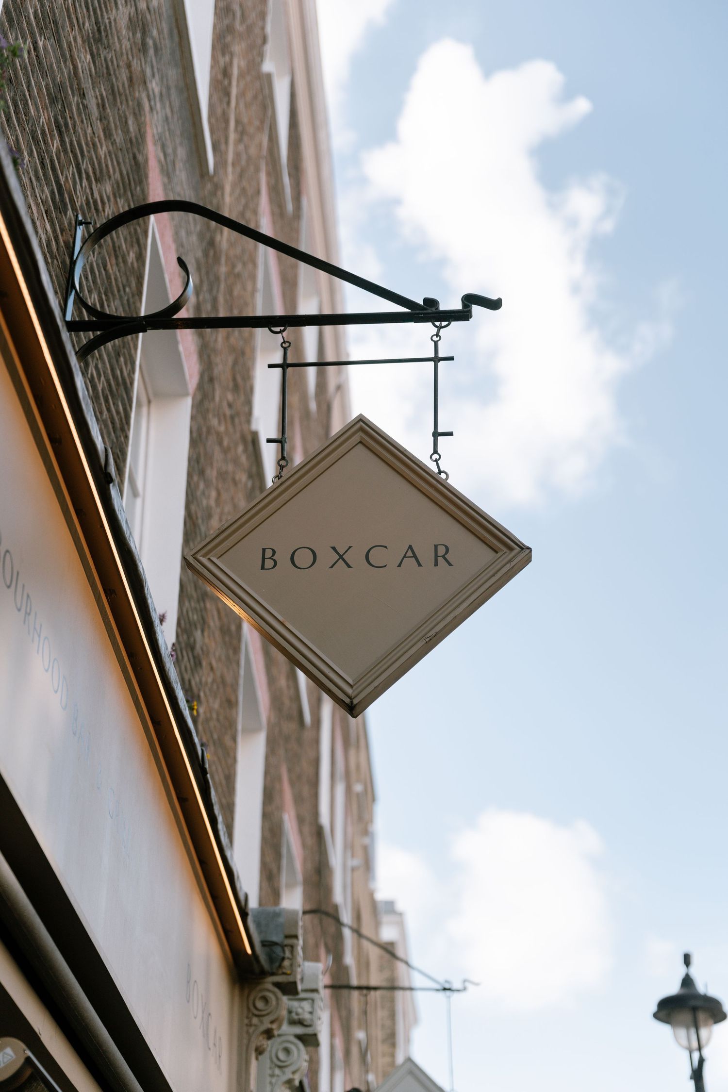 A vintage-style Boxcar sign mounted on a building exterior against a blue sky.