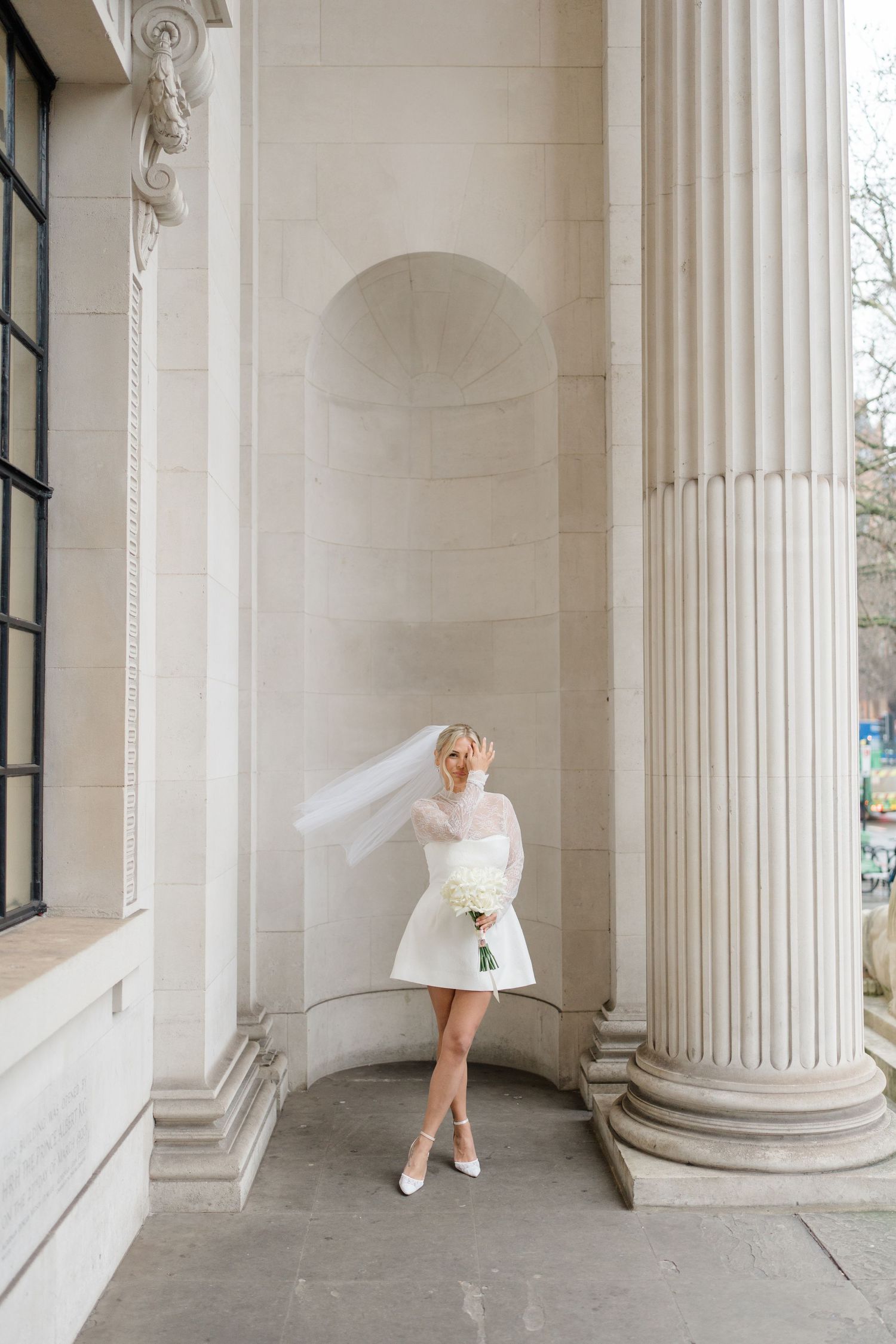 Artistic series showing a white dress against classical stone columns in natural light.