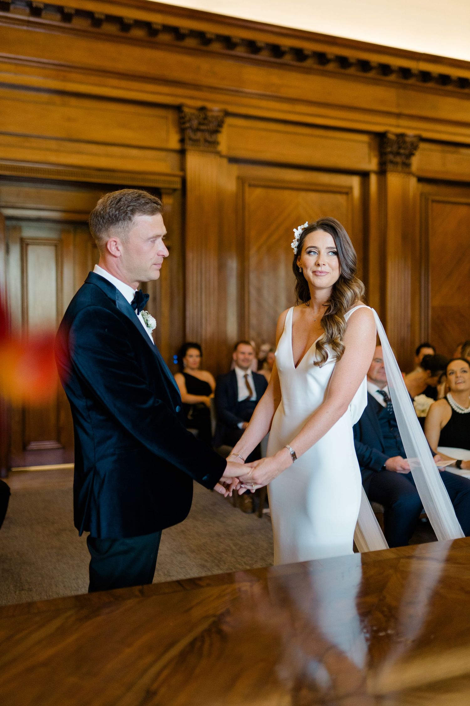Couple dancing in elegant wood-paneled room during wedding reception.