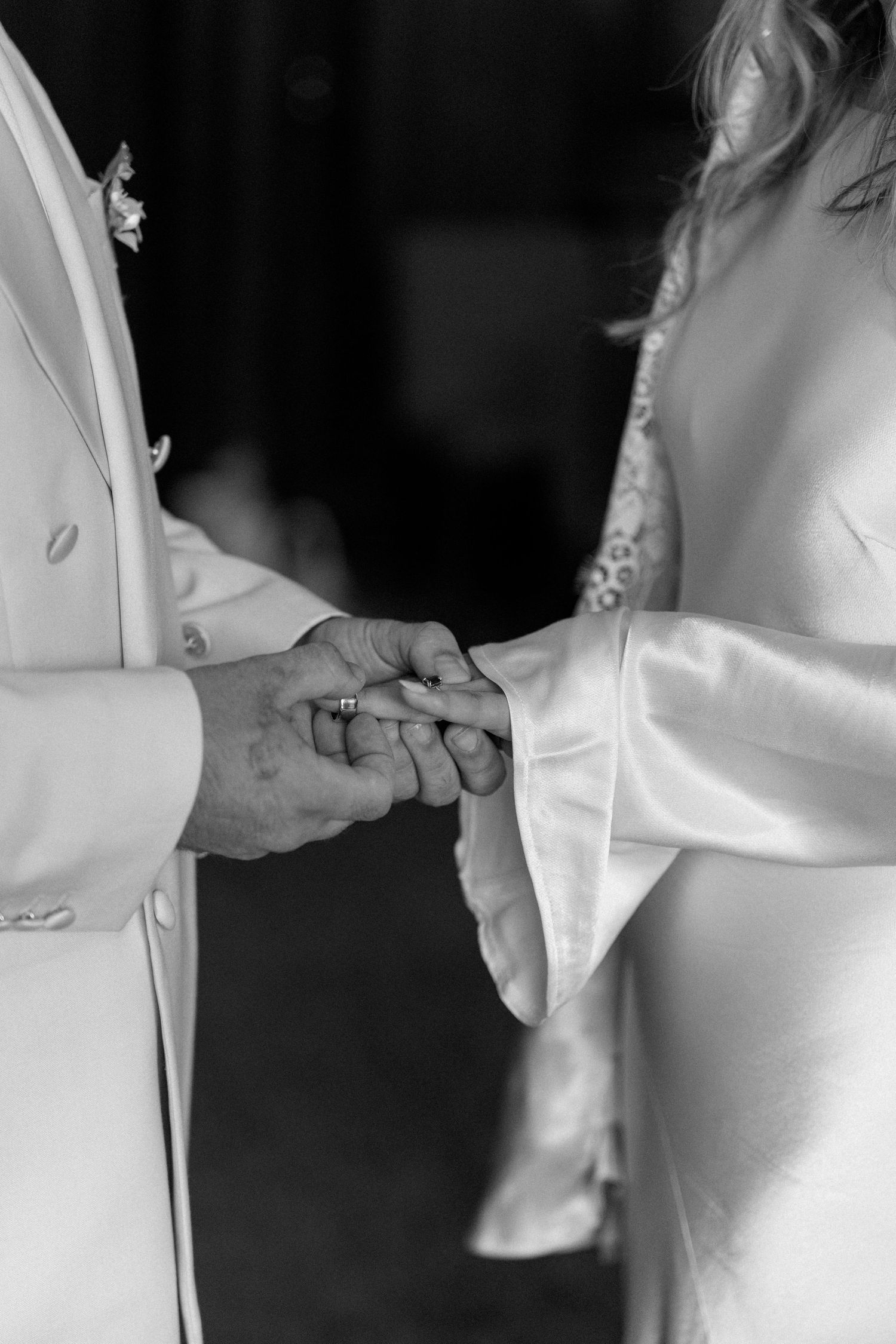 Close-up shots of hands during an intimate wedding ceremony moment.