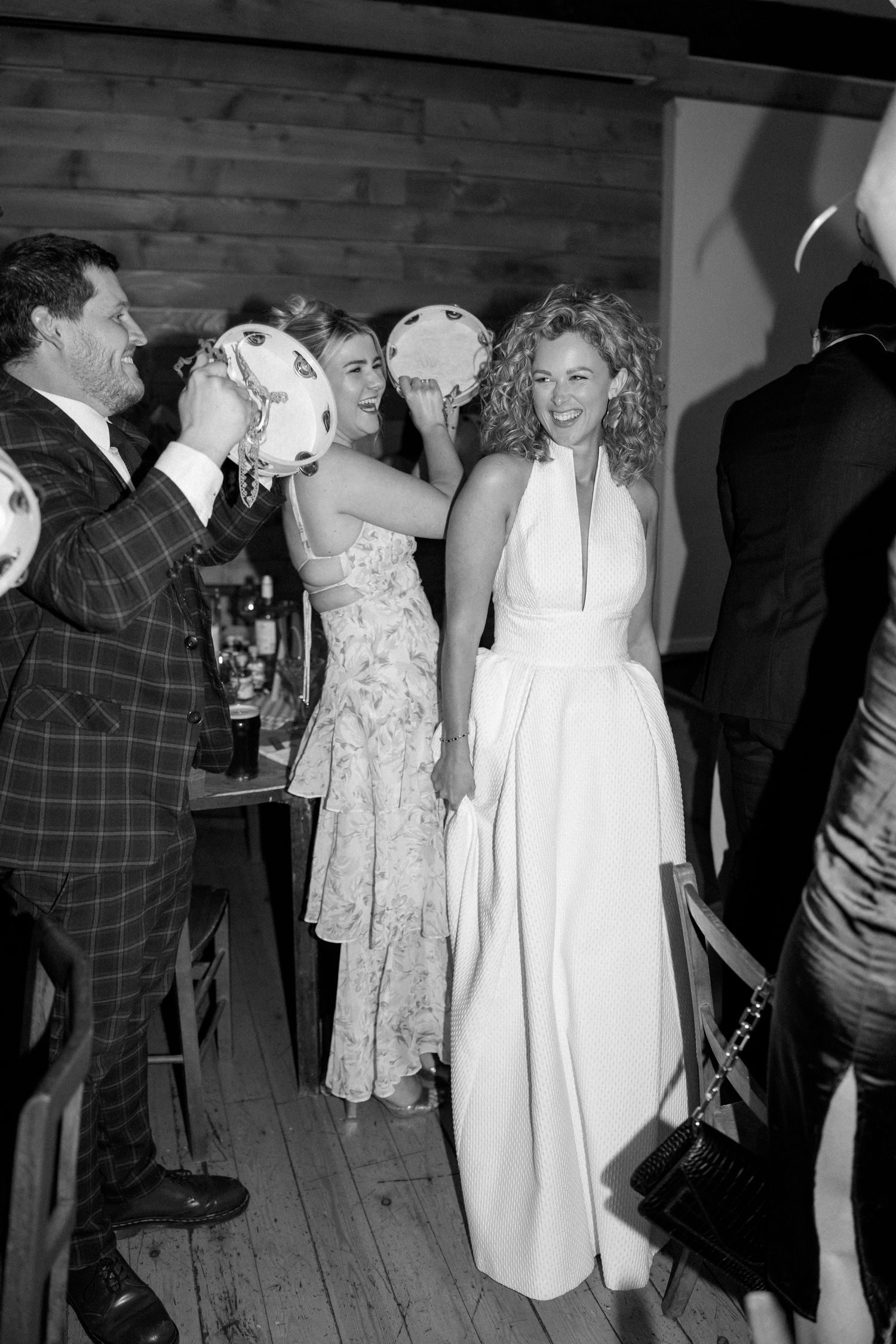 Wedding guests dancing and socializing at indoor reception.