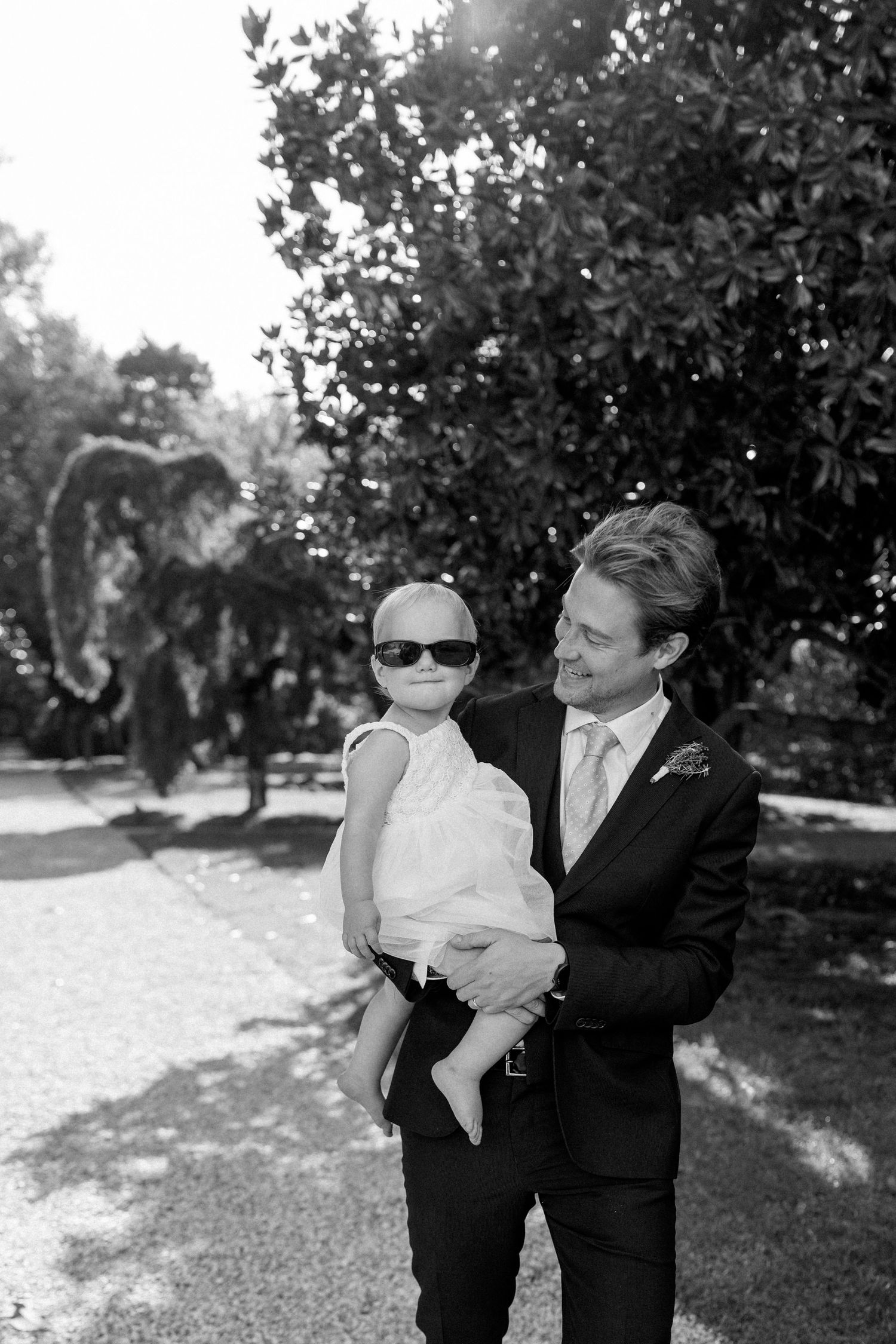 Black and white formal portrait sequence in an outdoor garden setting.