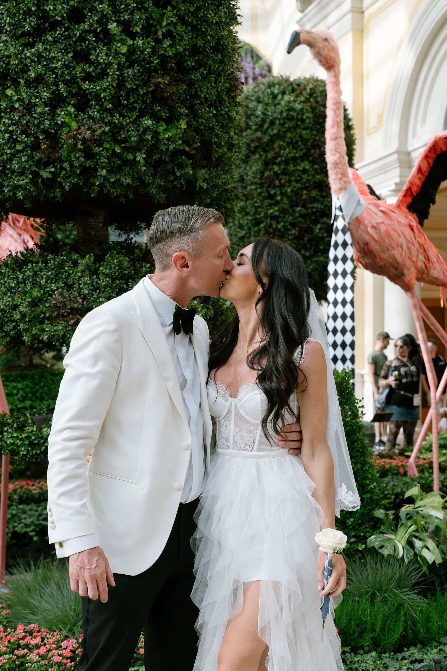 Romantic garden wedding photos with floral and greenery backdrop.