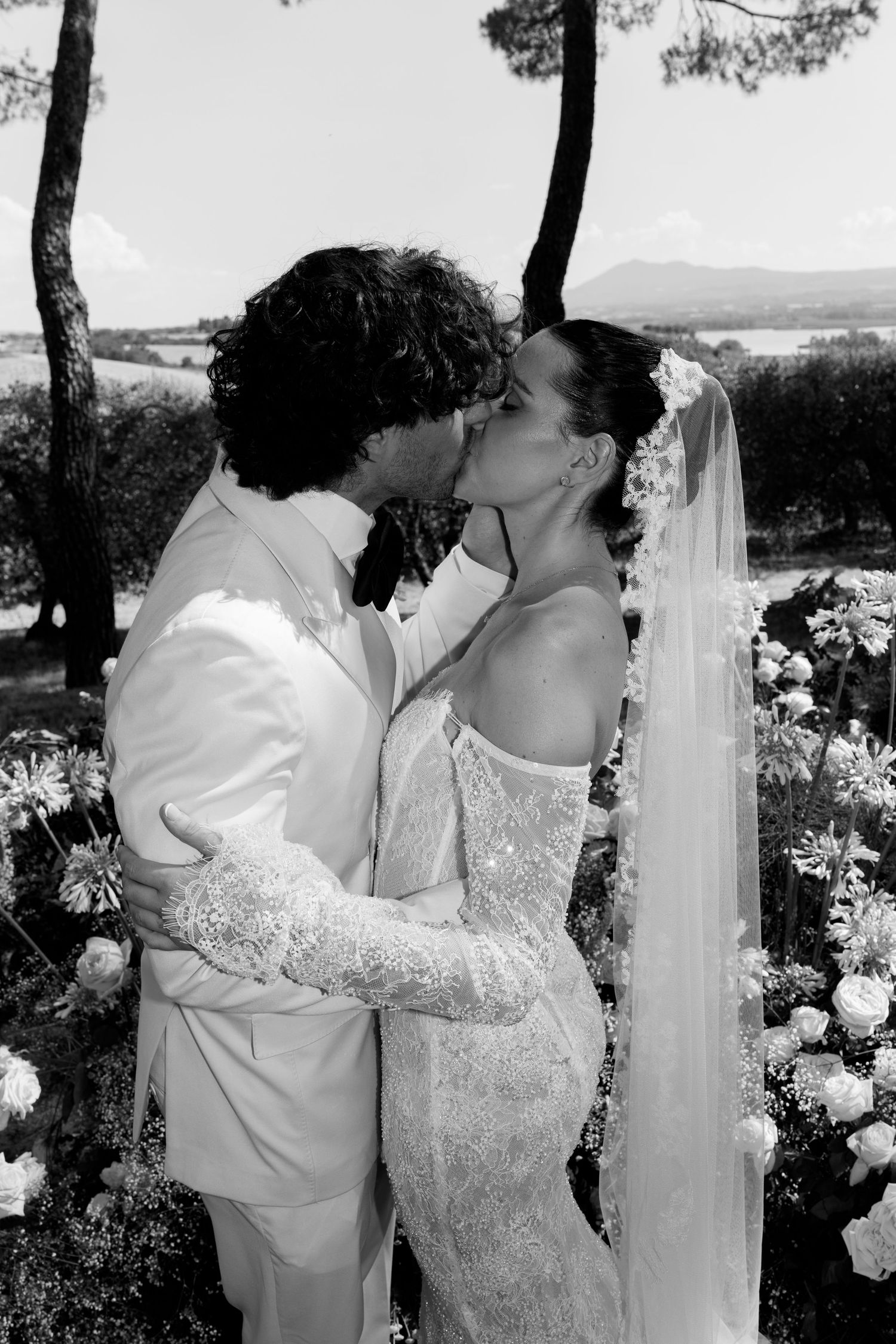 Black and white wedding photo series showing intimate moments between couple during outdoor celebration.