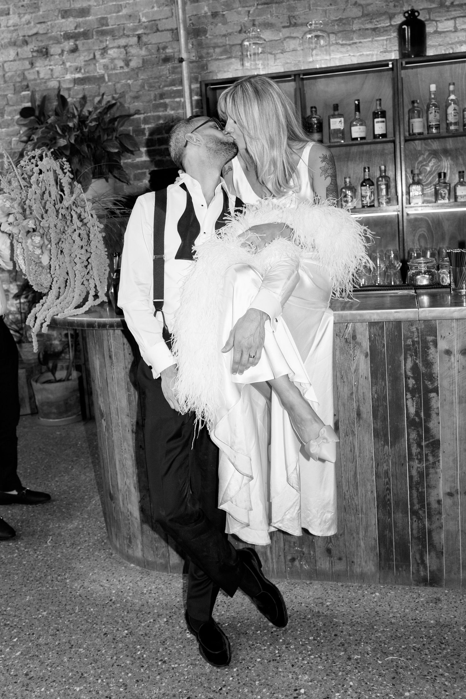 Wedding celebration candid moments at a rustic venue with exposed brick bar.