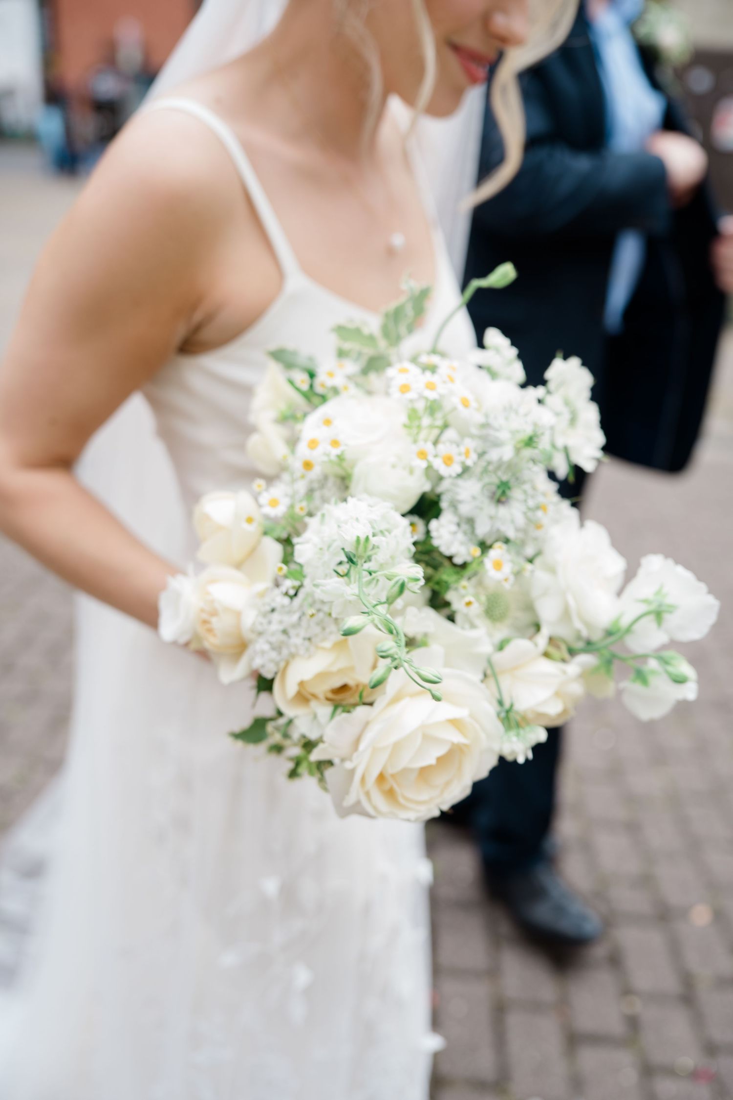 Delicate white and cream bridal bouquet with roses and mixed flowers.
