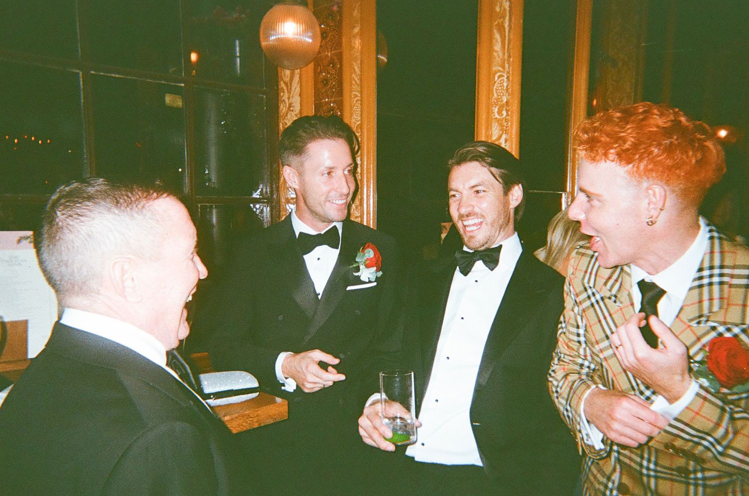 Vintage photograph of people gathered at formal dinner event in warm lighting.