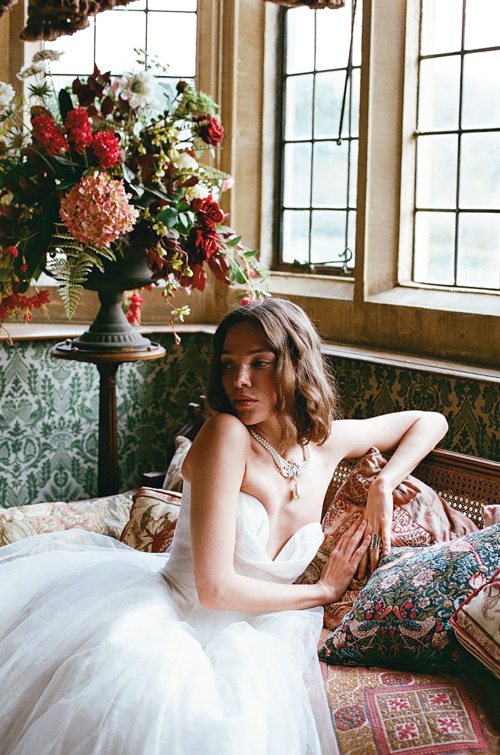 A romantic bridal portrait series featuring a flowing white gown and floral crown in a vintage-style interior setting.