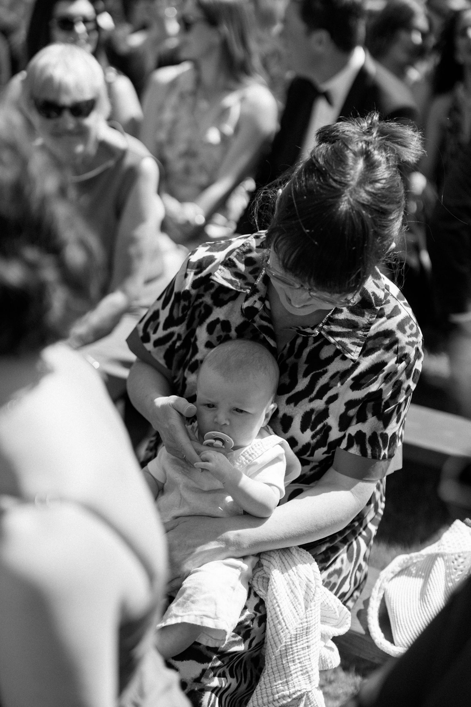 A tender moment between parent and child during an outdoor gathering.