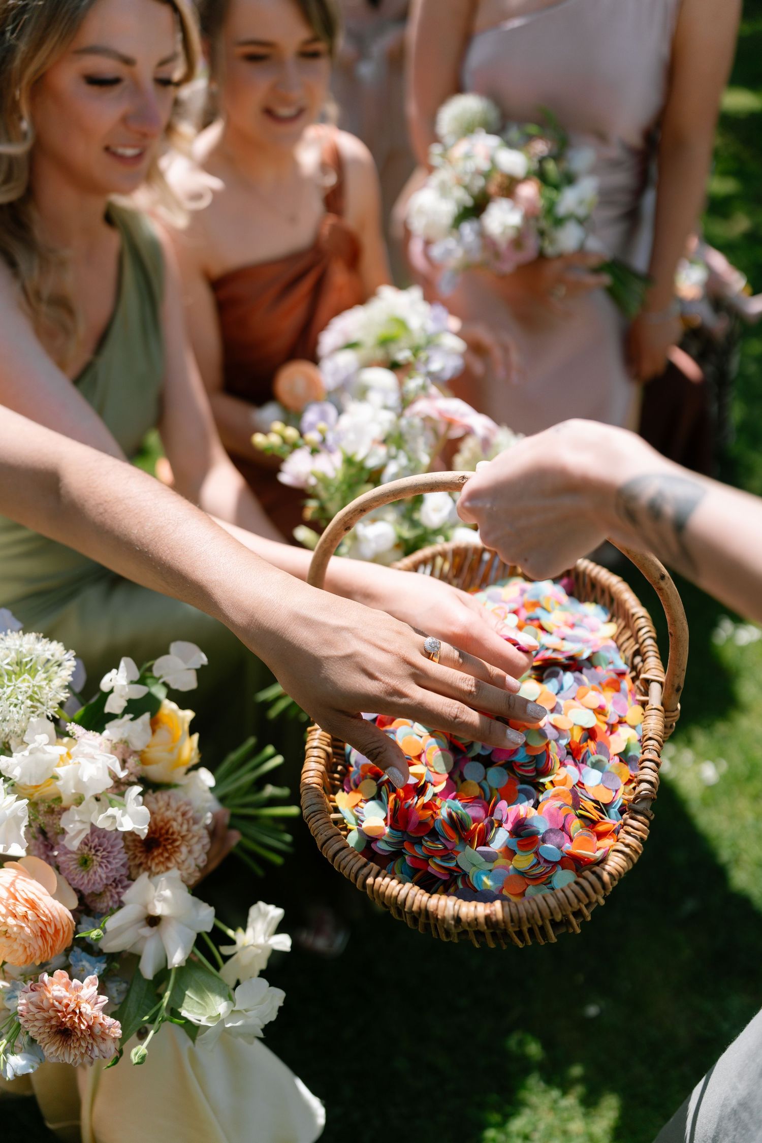 Wedding guests hold woven baskets filled with colorful flower petals for the ceremony toss.