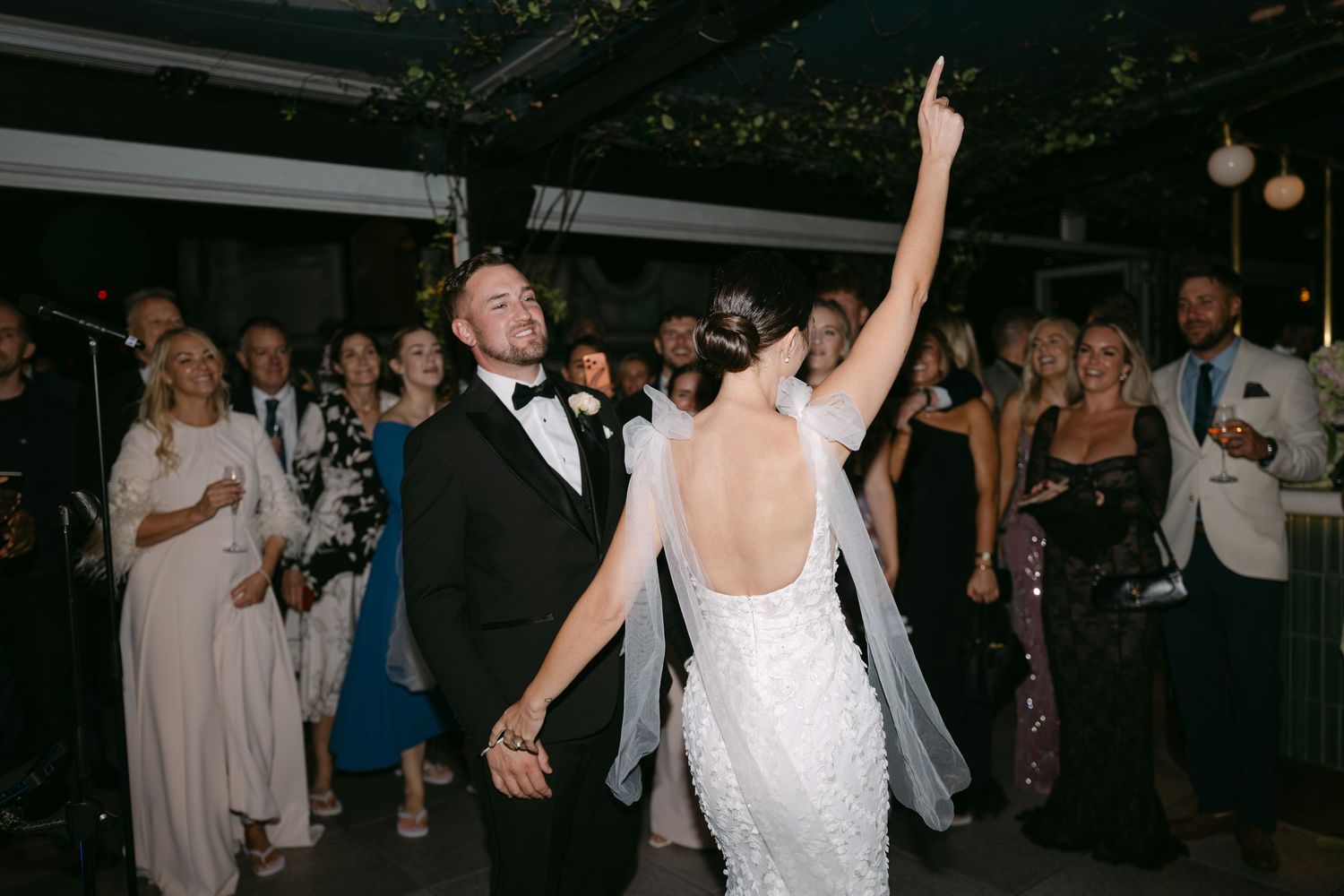 Wedding guests dance and celebrate on the dance floor during an evening reception.