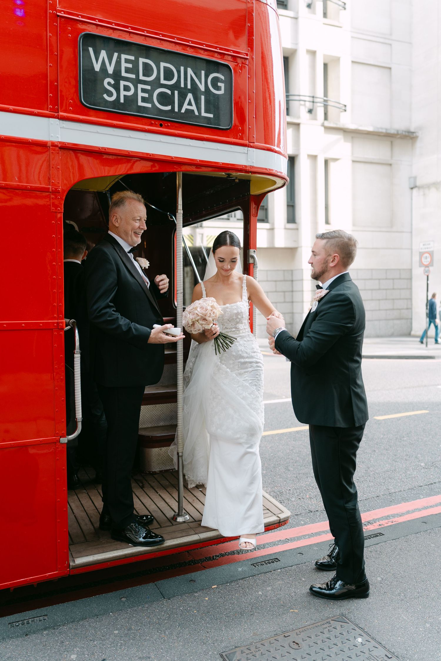 Wedding party boarding a classic red London bus marked 'Wedding Special'.