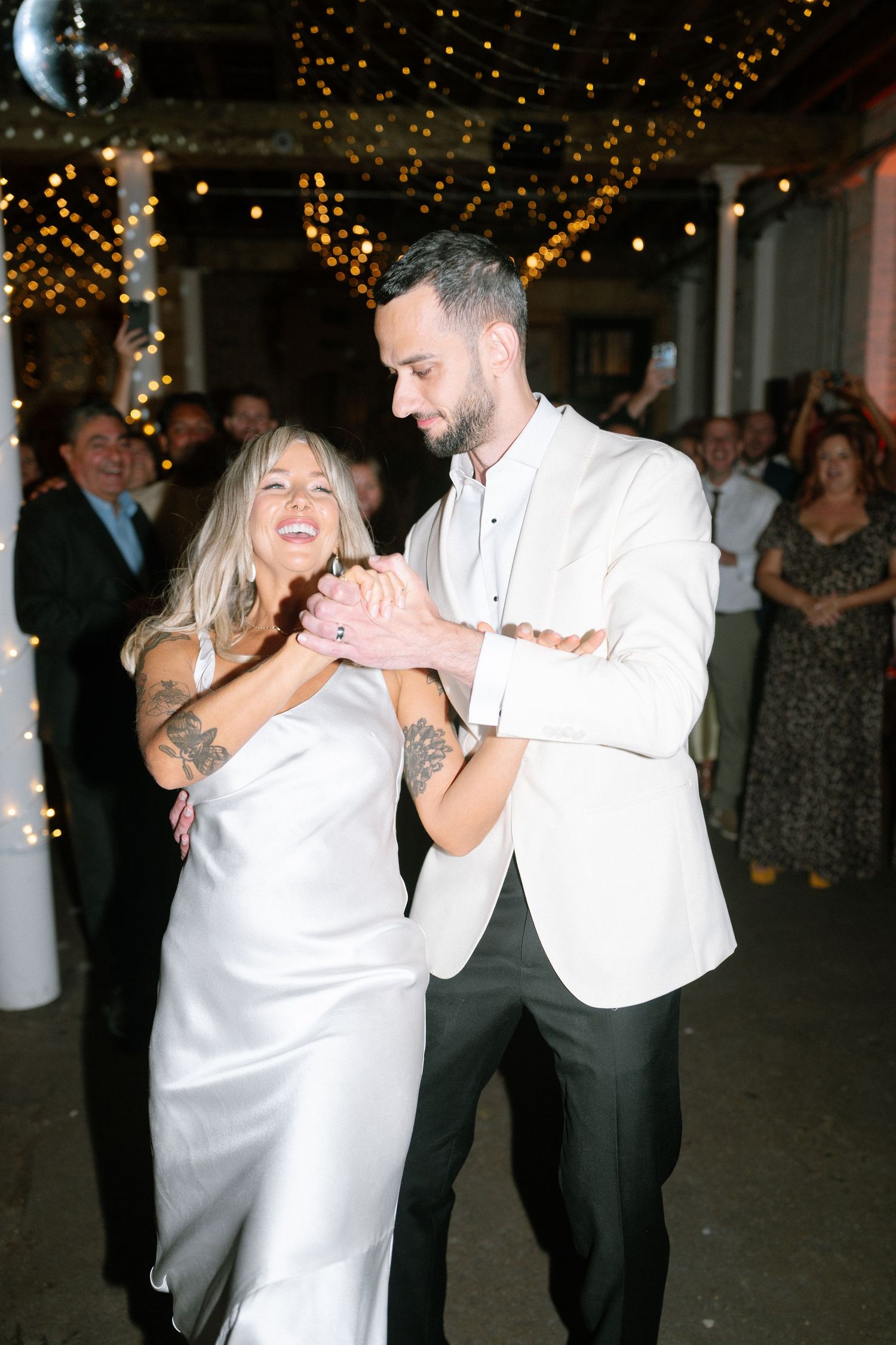 Couples dancing together under twinkling lights at an elegant evening celebration.