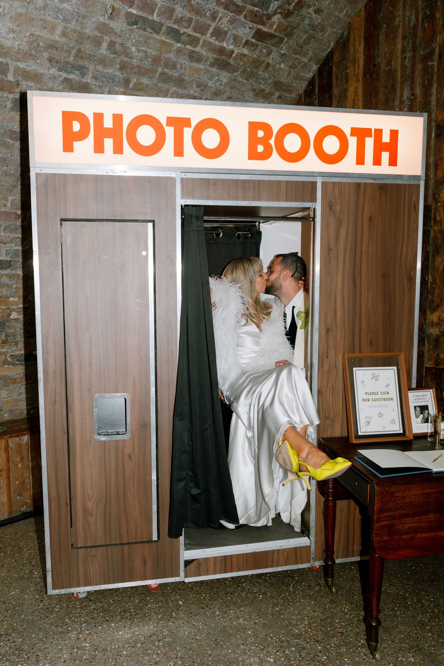 Retro-style photo booth setup with wooden panels at a wedding venue.