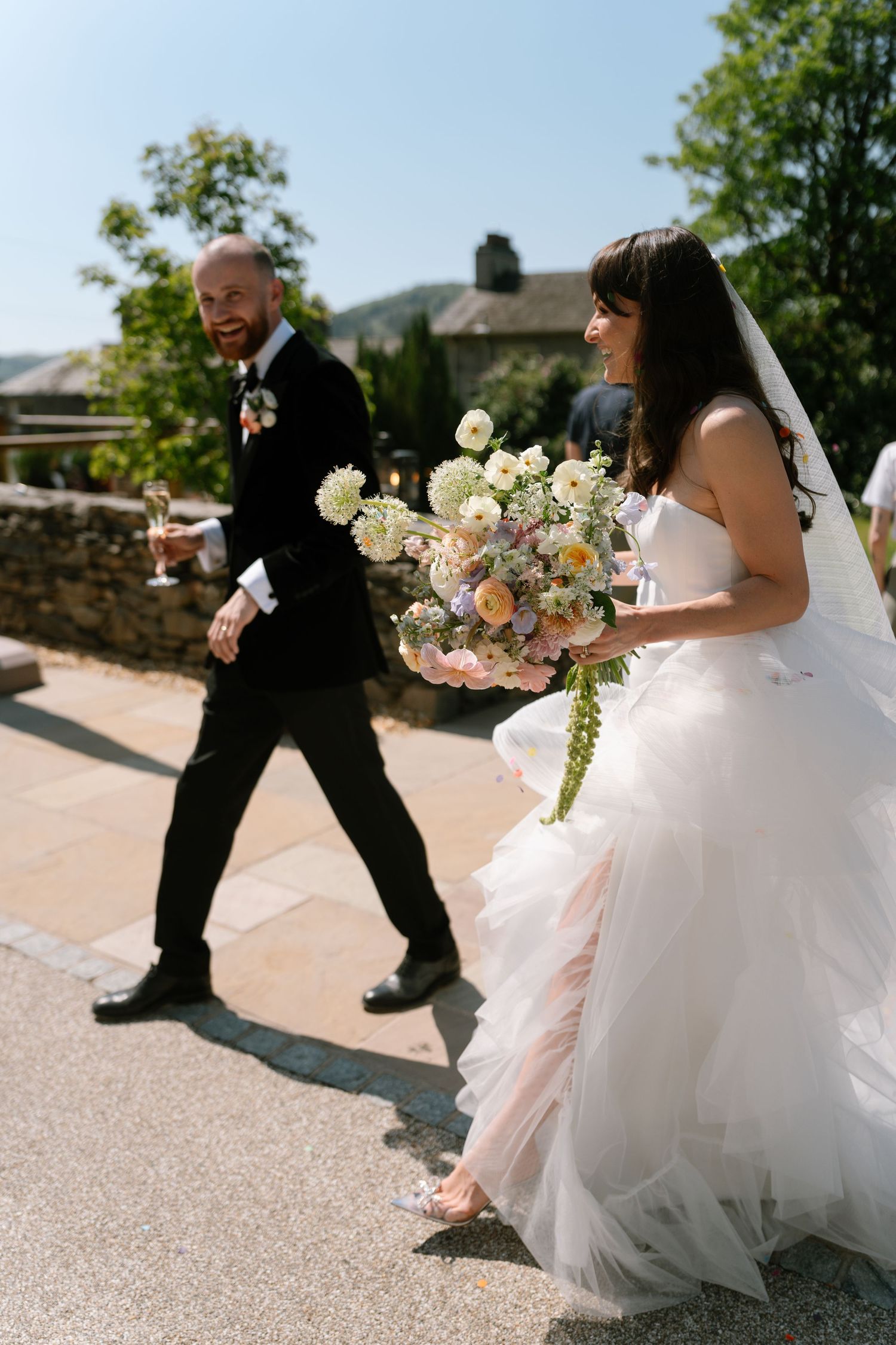 A playful sequence of a couple dancing with the bride's white dress flowing in the sunlight.