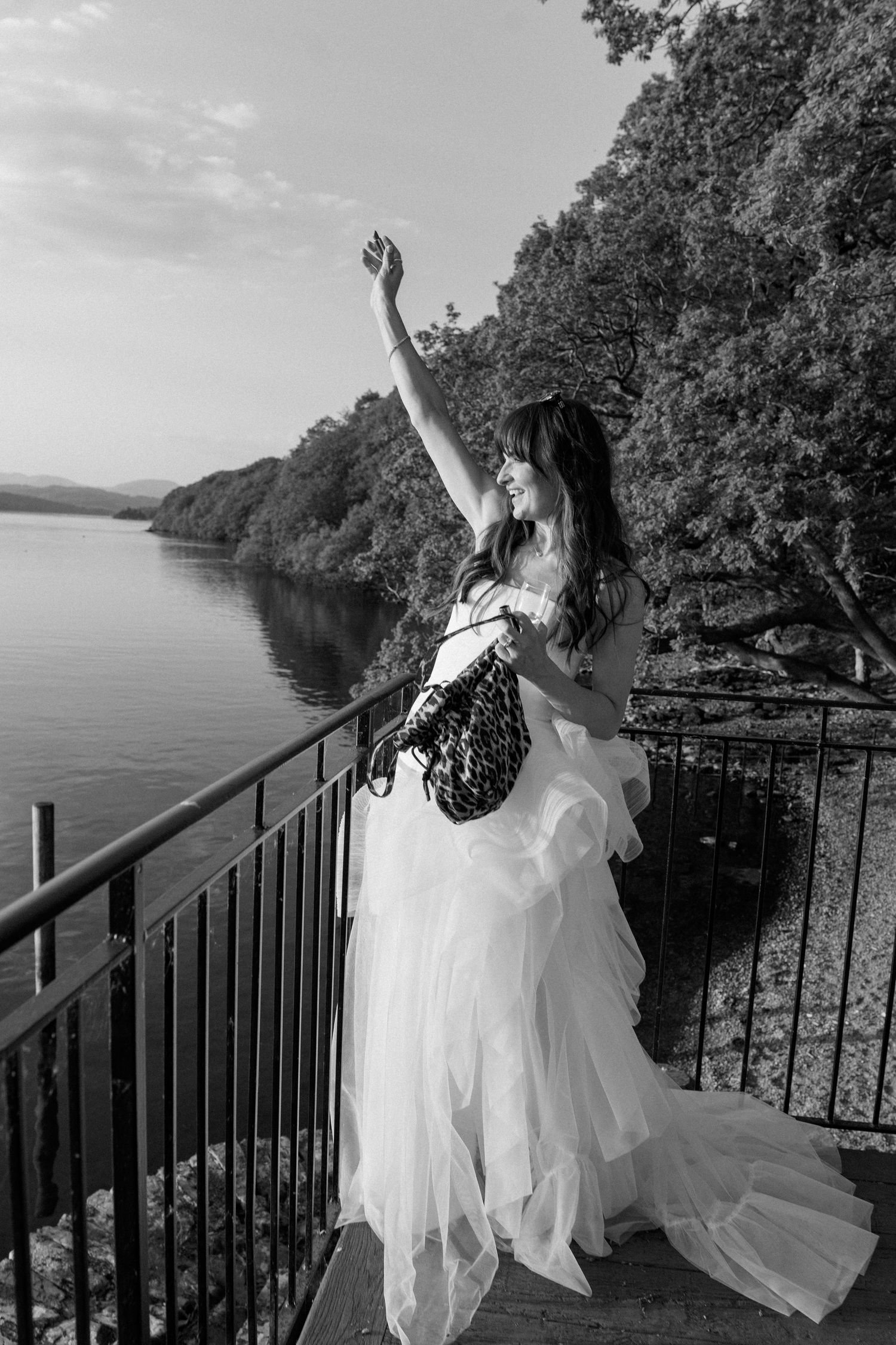 A joyful celebration on a deck overlooking a scenic lake with trees in the background.