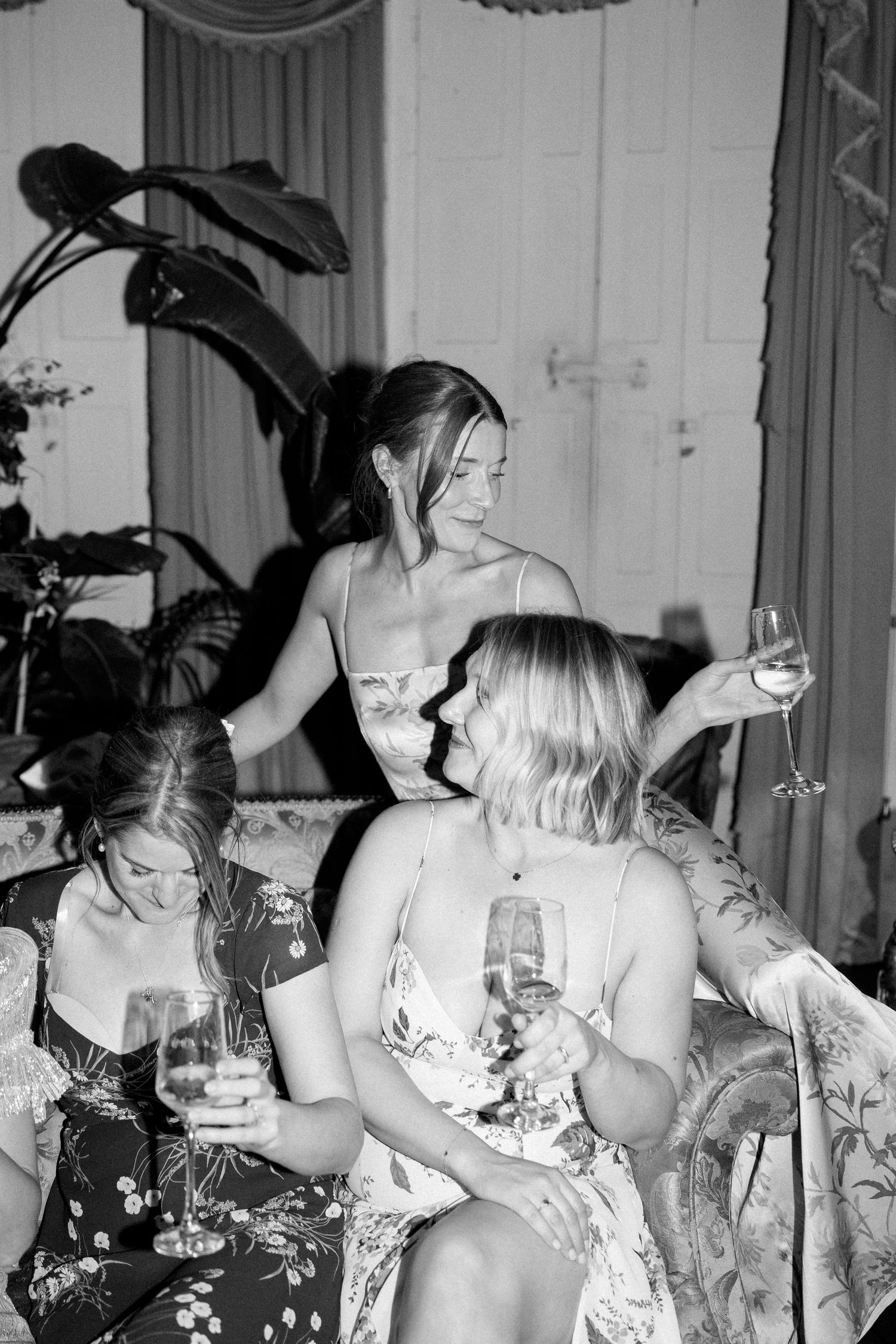 Black and white photo of party guests drinking and celebrating in formal attire.