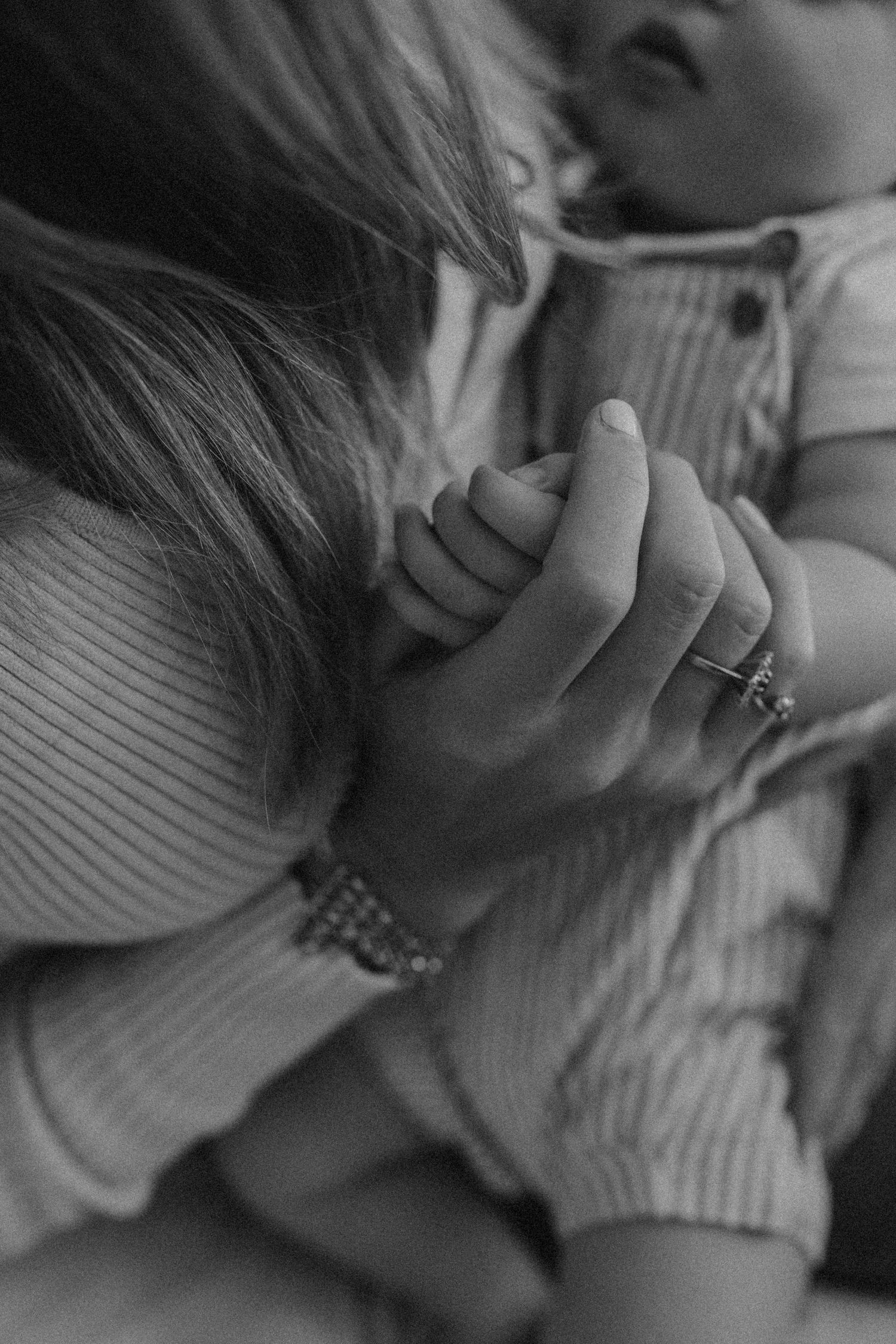 Close-up black and white sequence showing hands and a ring in an intimate moment.