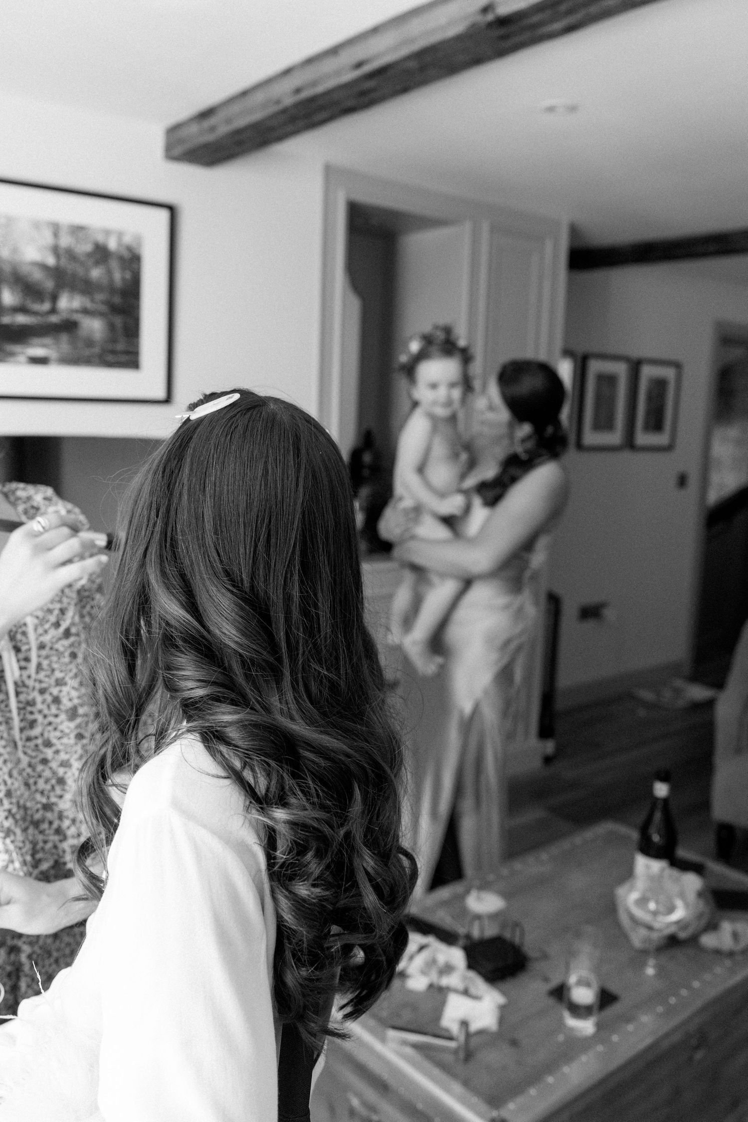 Black and white candid photo of wedding preparation moments indoors.
