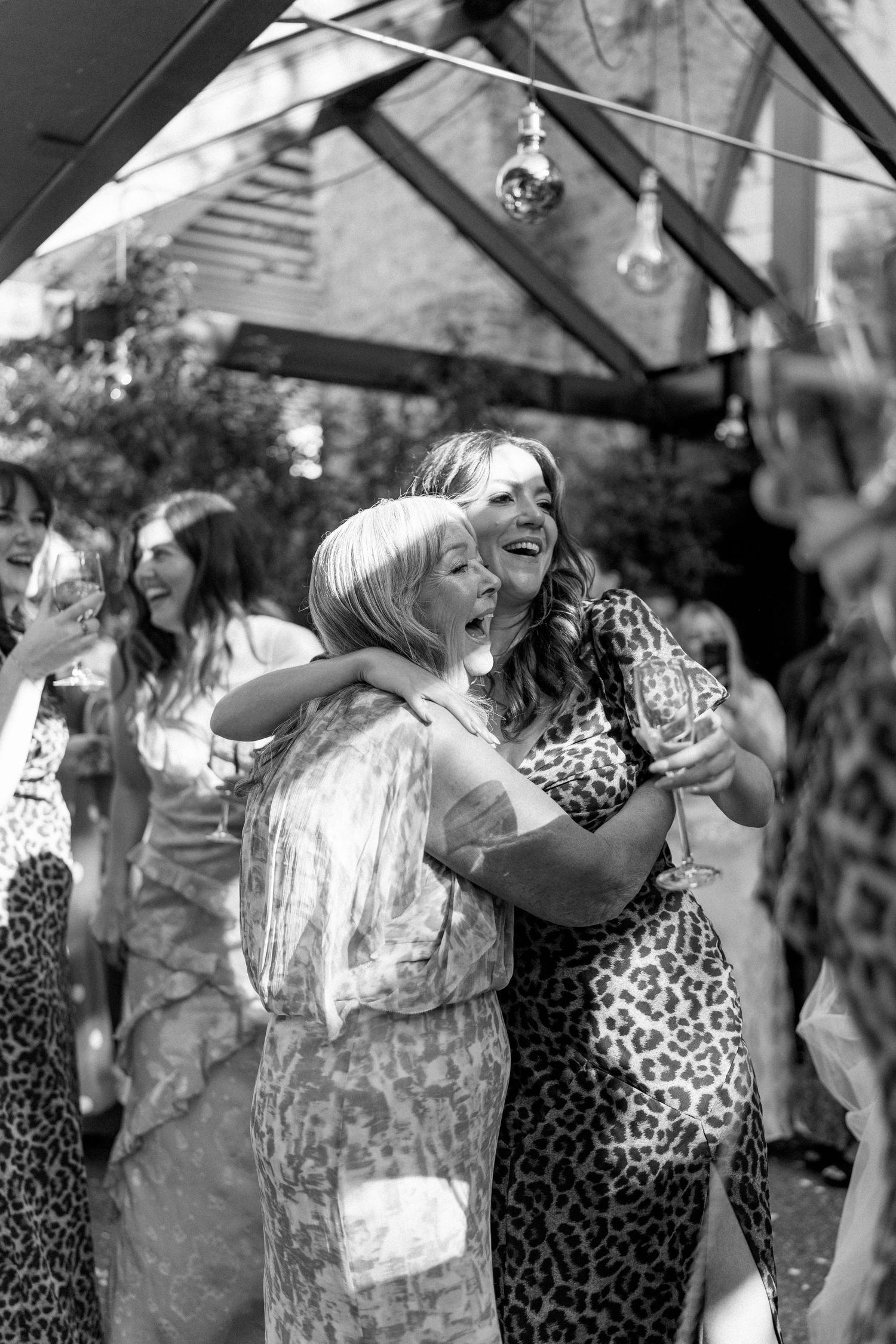 Wedding celebration candid moments captured under outdoor string lights.