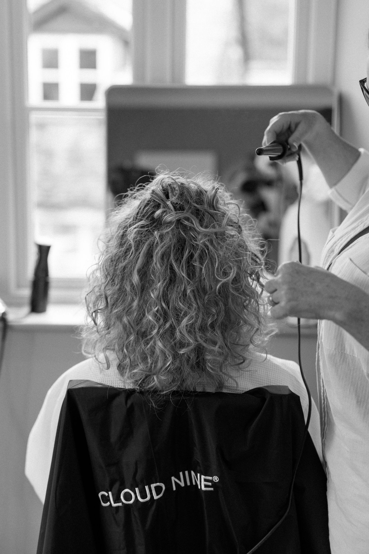 Professional hair styling session in progress showing curly hair being styled.