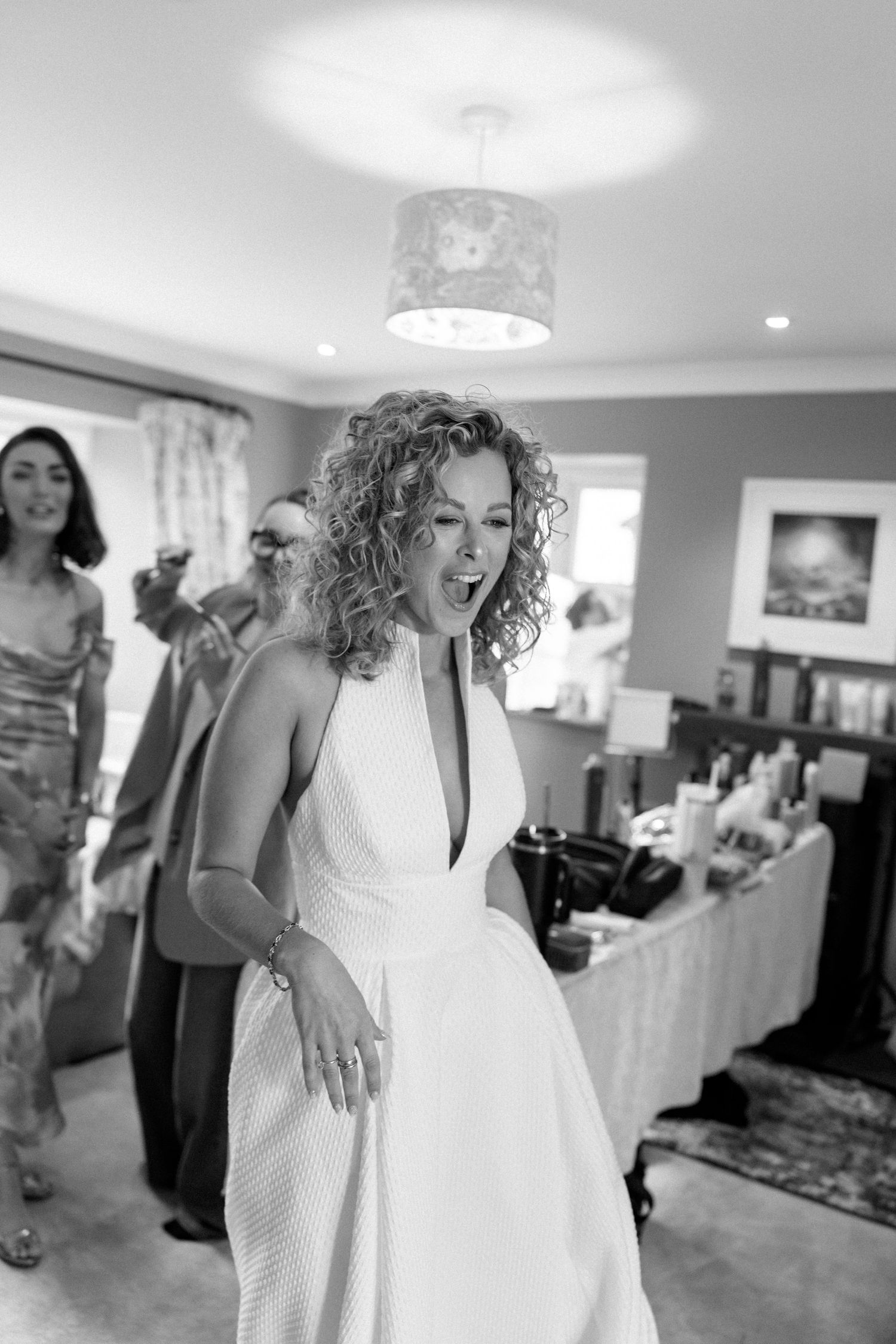 A series of black and white photos showing wedding preparations with a bride in a white dress.