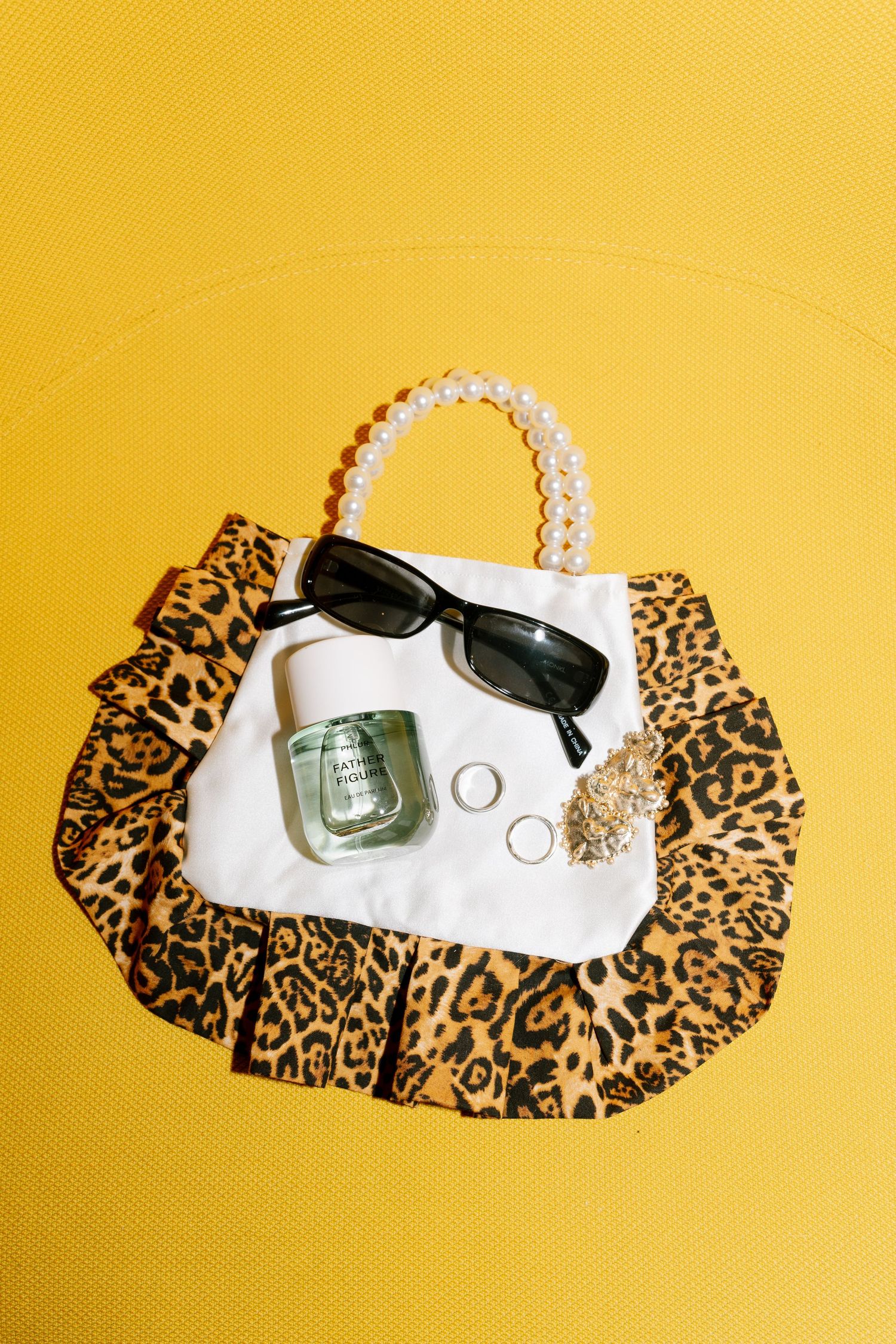 Wedding accessories including sunglasses and leopard print fabric against bright yellow background.