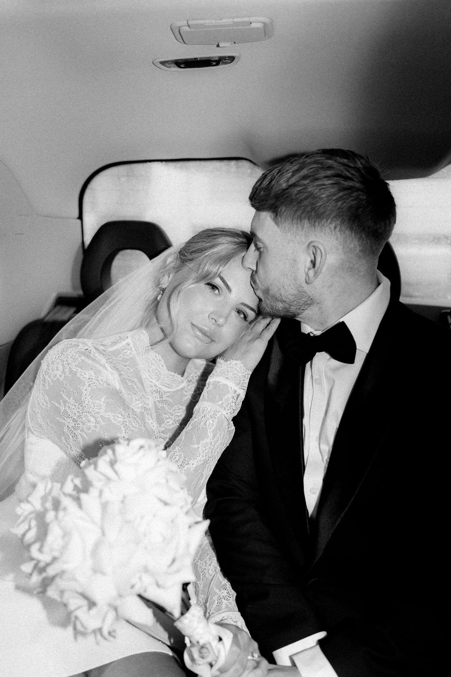 Black and white candid photos of a couple sharing intimate moments in a car.
