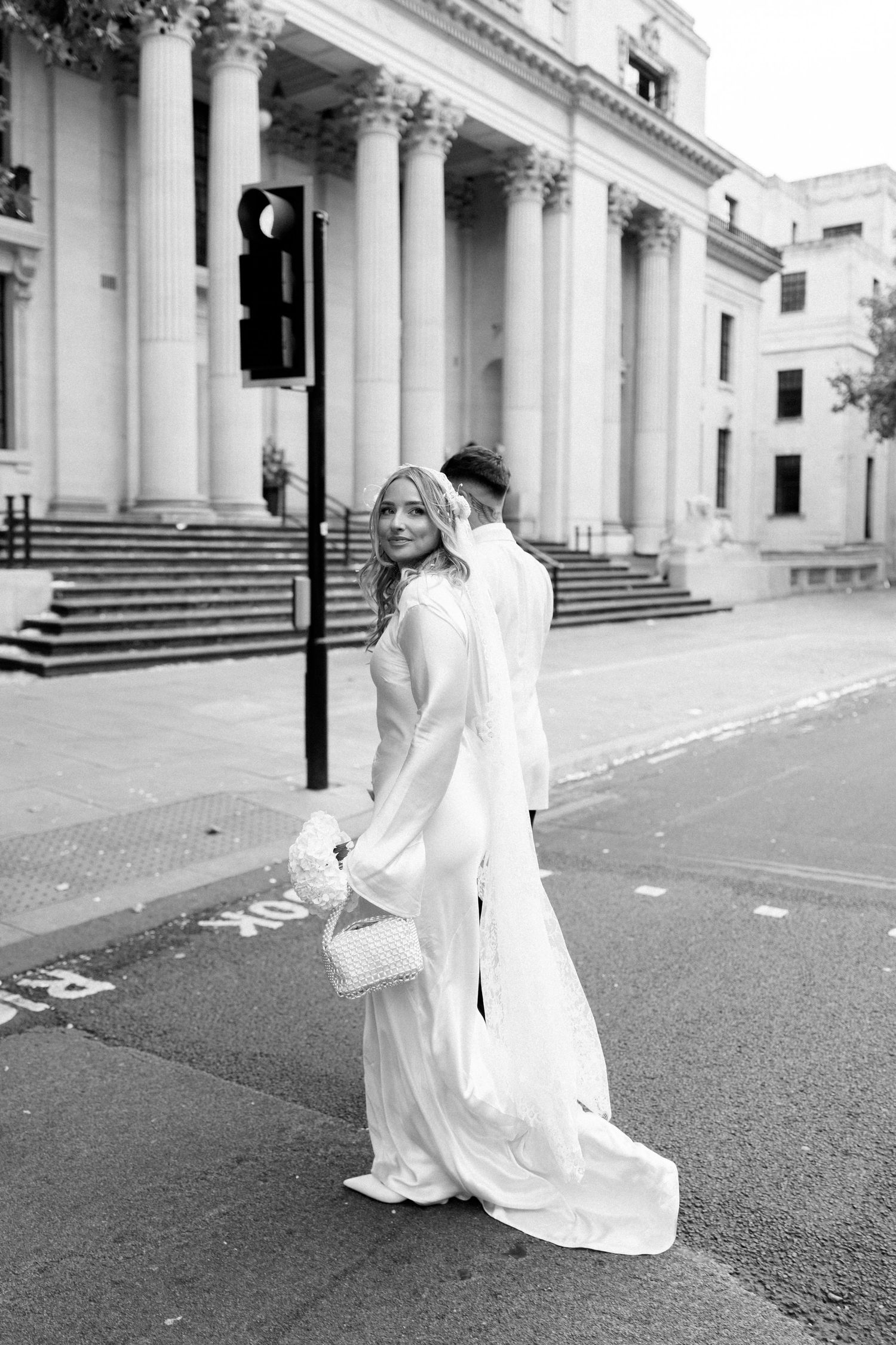 Black and white photos of couple dancing outside classical building.