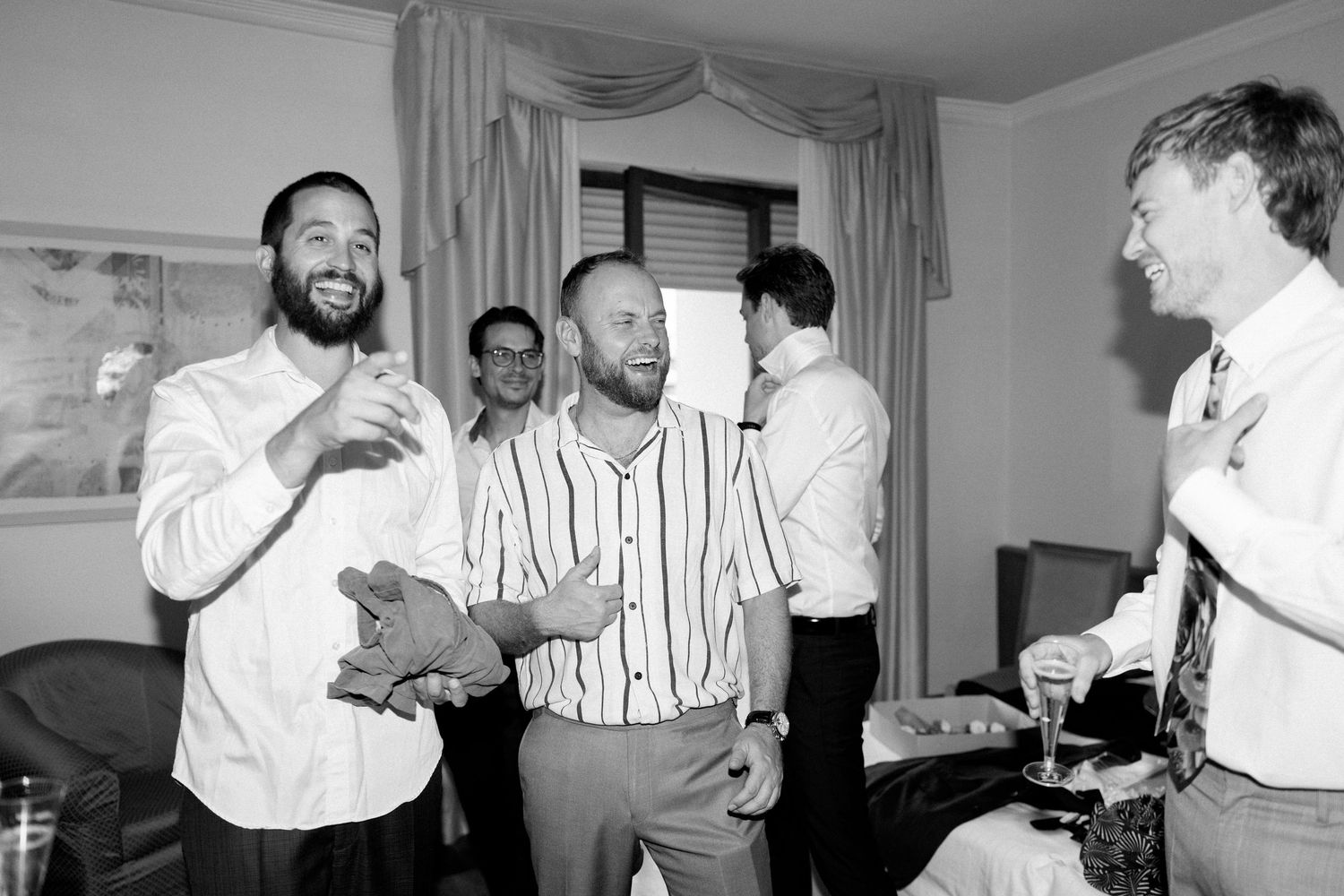 Group of men in formal attire dancing and celebrating at an event.