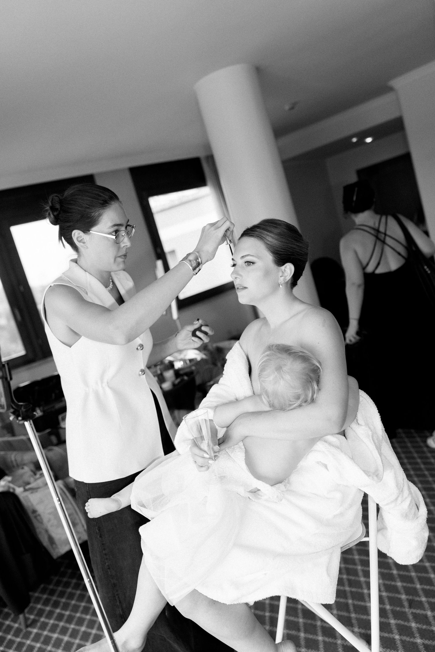 A tender moment captured during wedding preparations as people embrace in black and white photography.