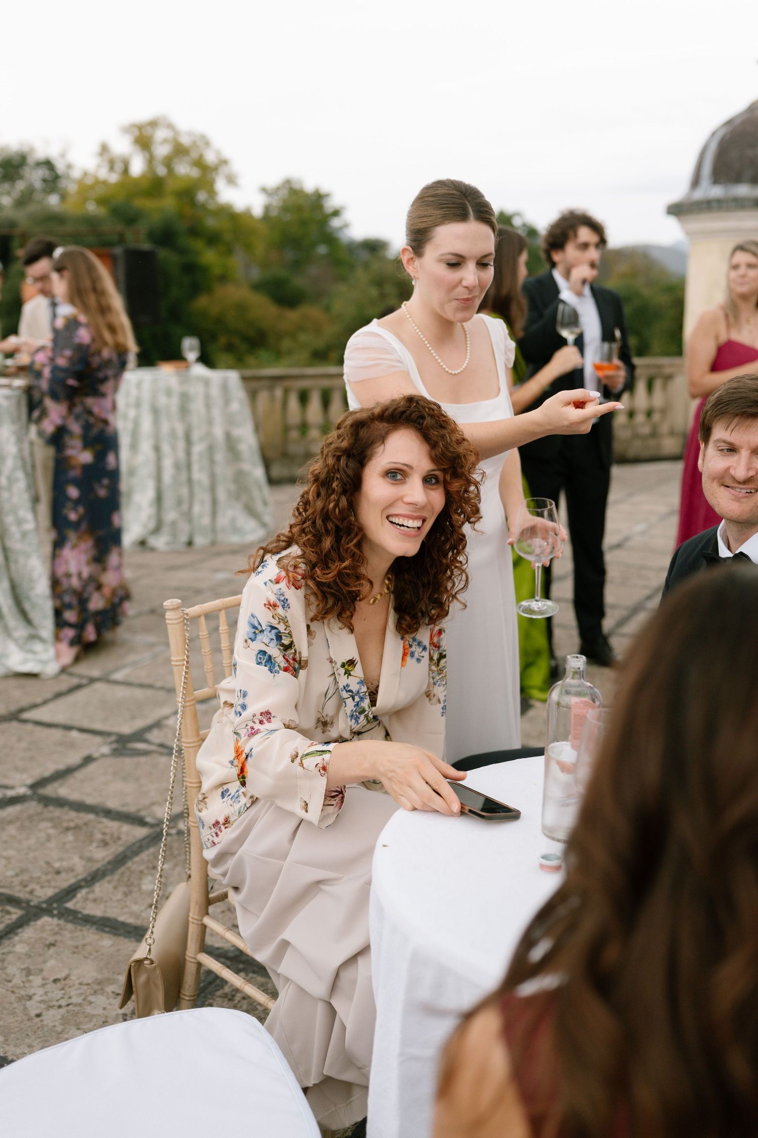 Wedding guests enjoying conversation at an outdoor reception.