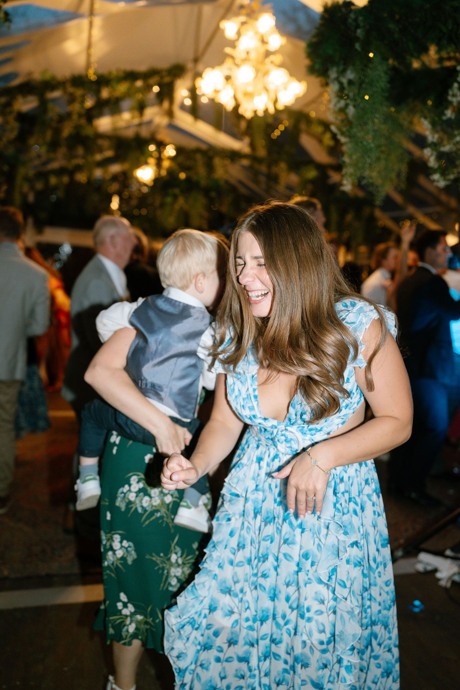 Guests in blue floral dresses dancing and enjoying themselves at an evening celebration.