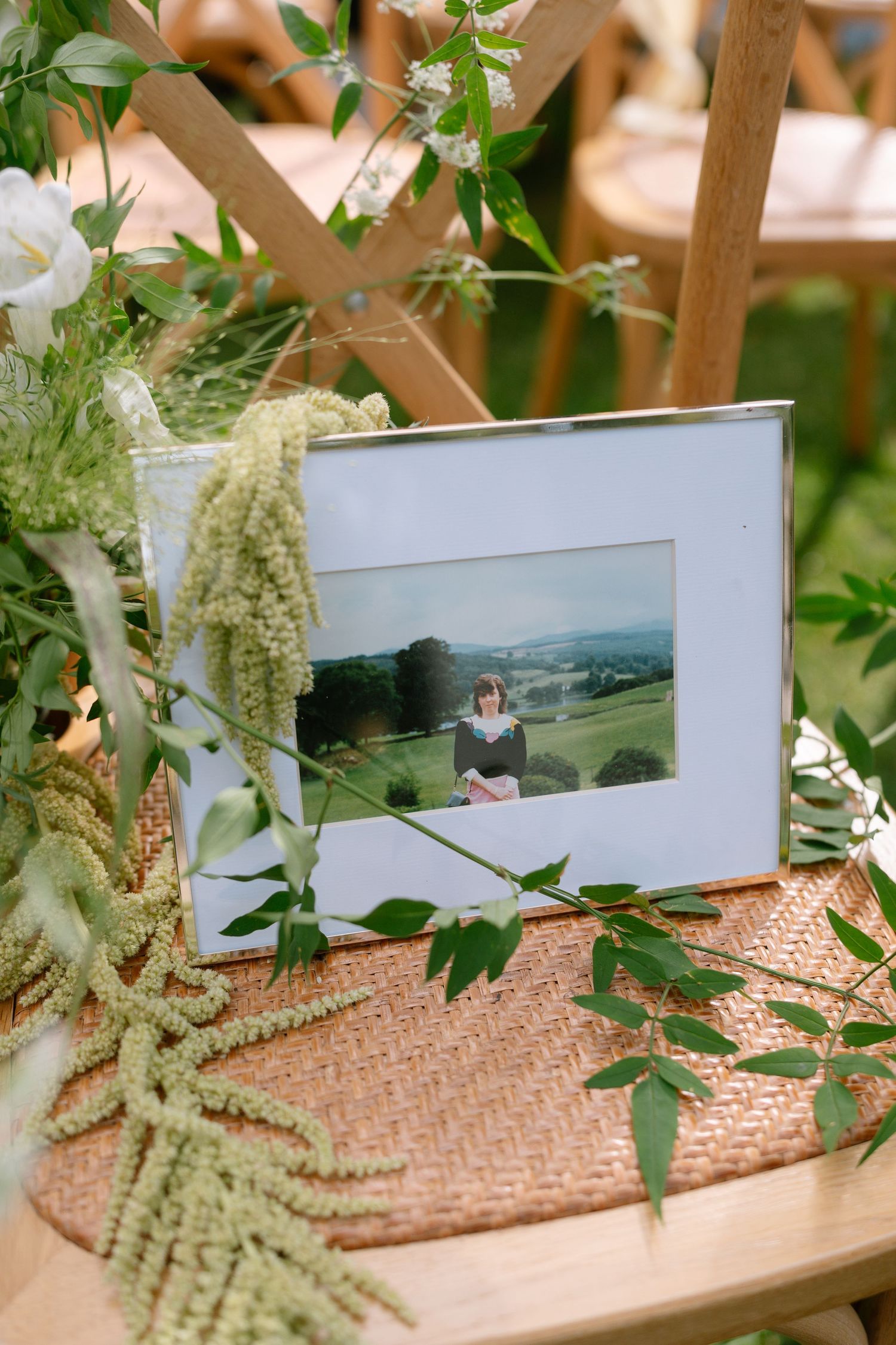 Framed photograph displayed on a rustic surface with delicate greenery and natural decor.