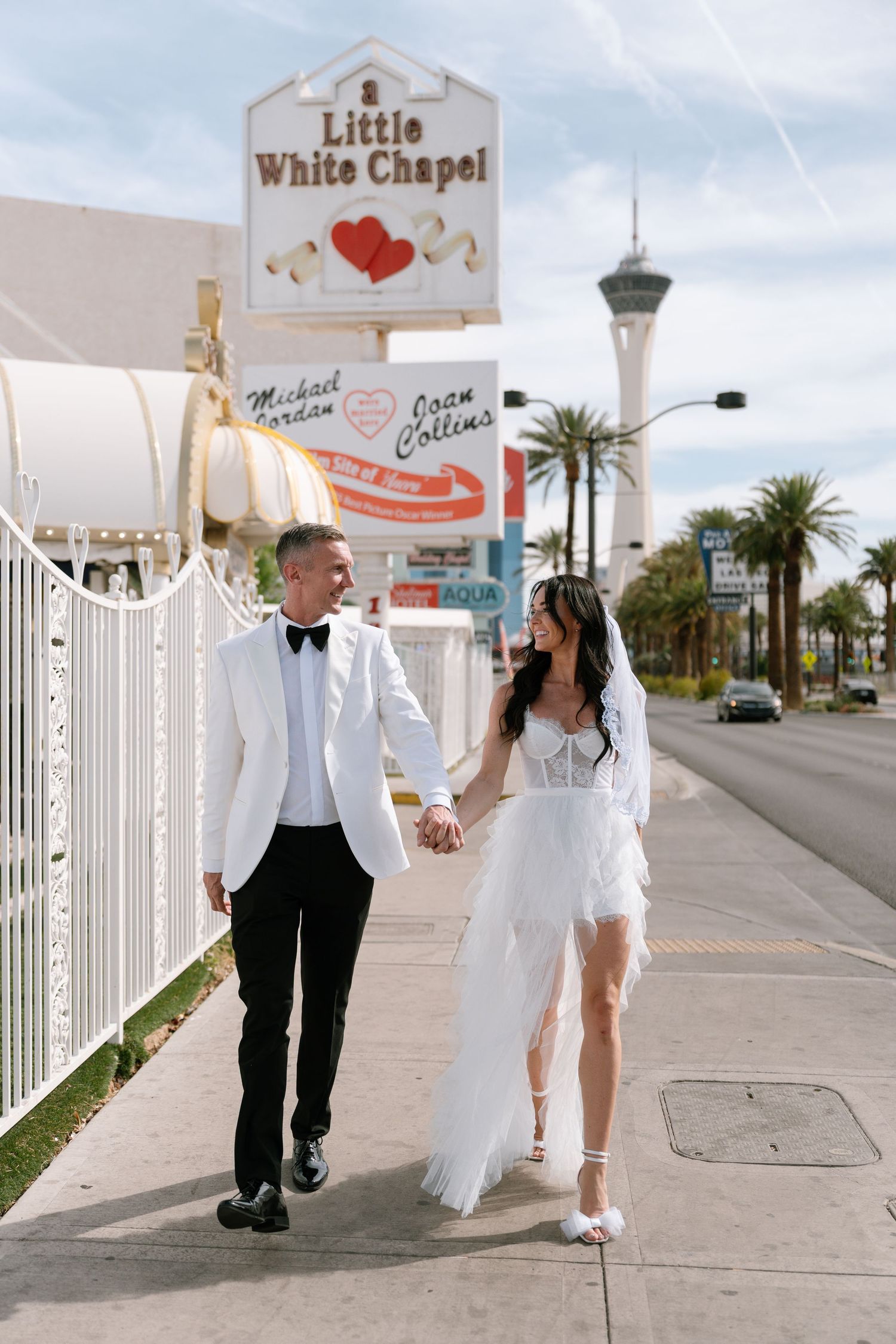 Wedding couple walks outside the Little White Chapel in Las Vegas.