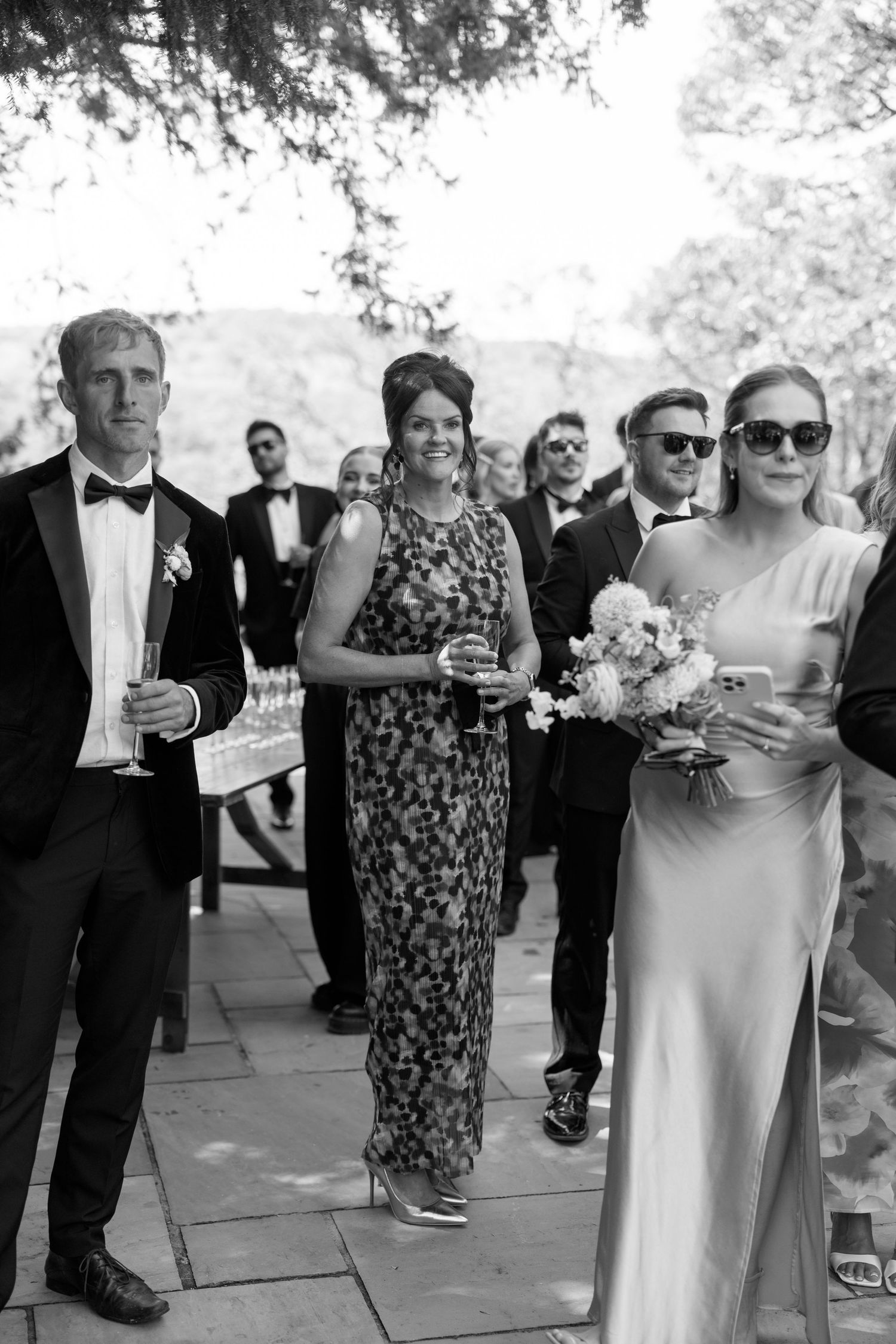 Elegantly dressed wedding guests in formal attire gather during the celebration.