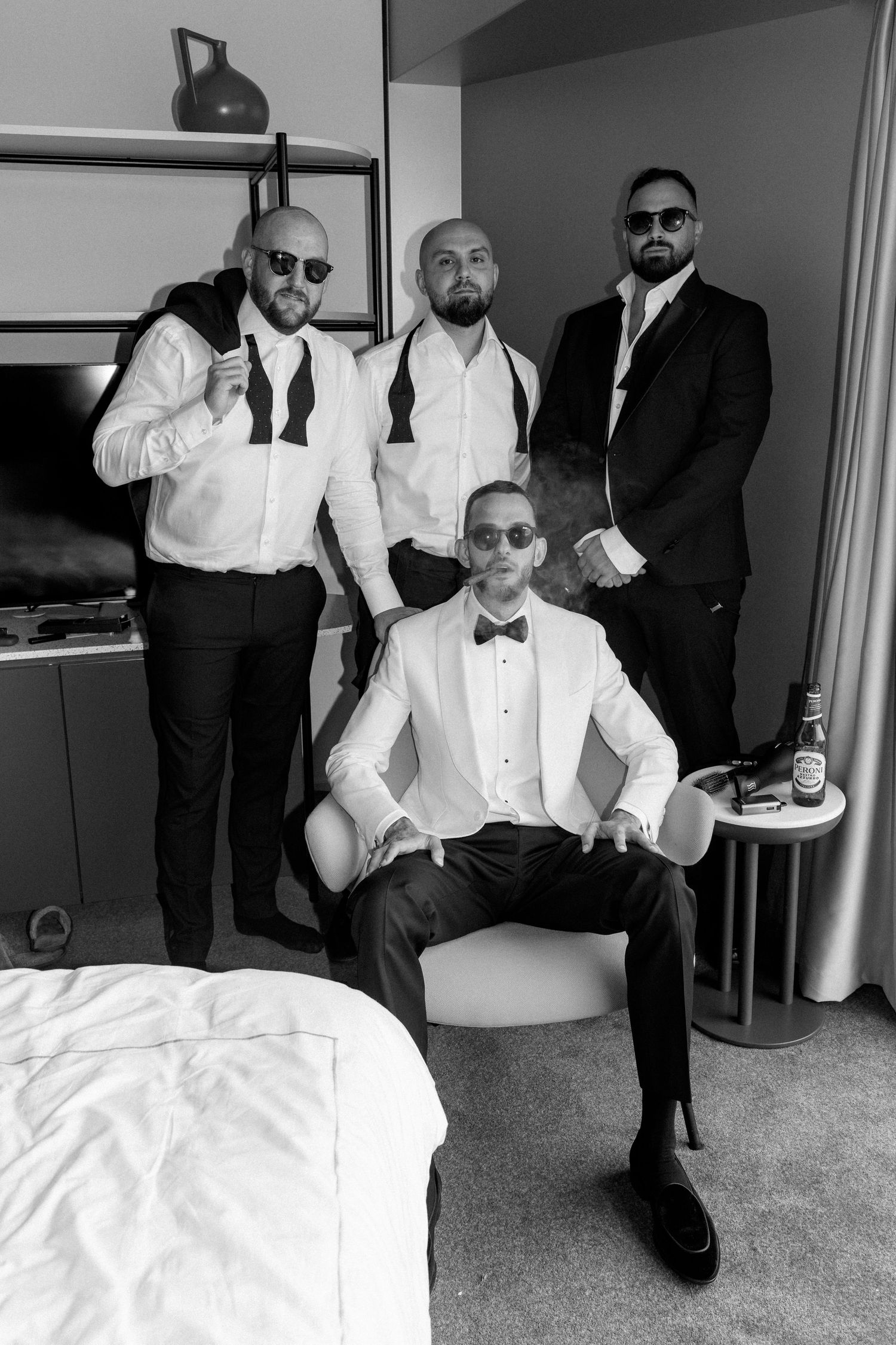 Black and white photo series of groomsmen in formal attire posing together.