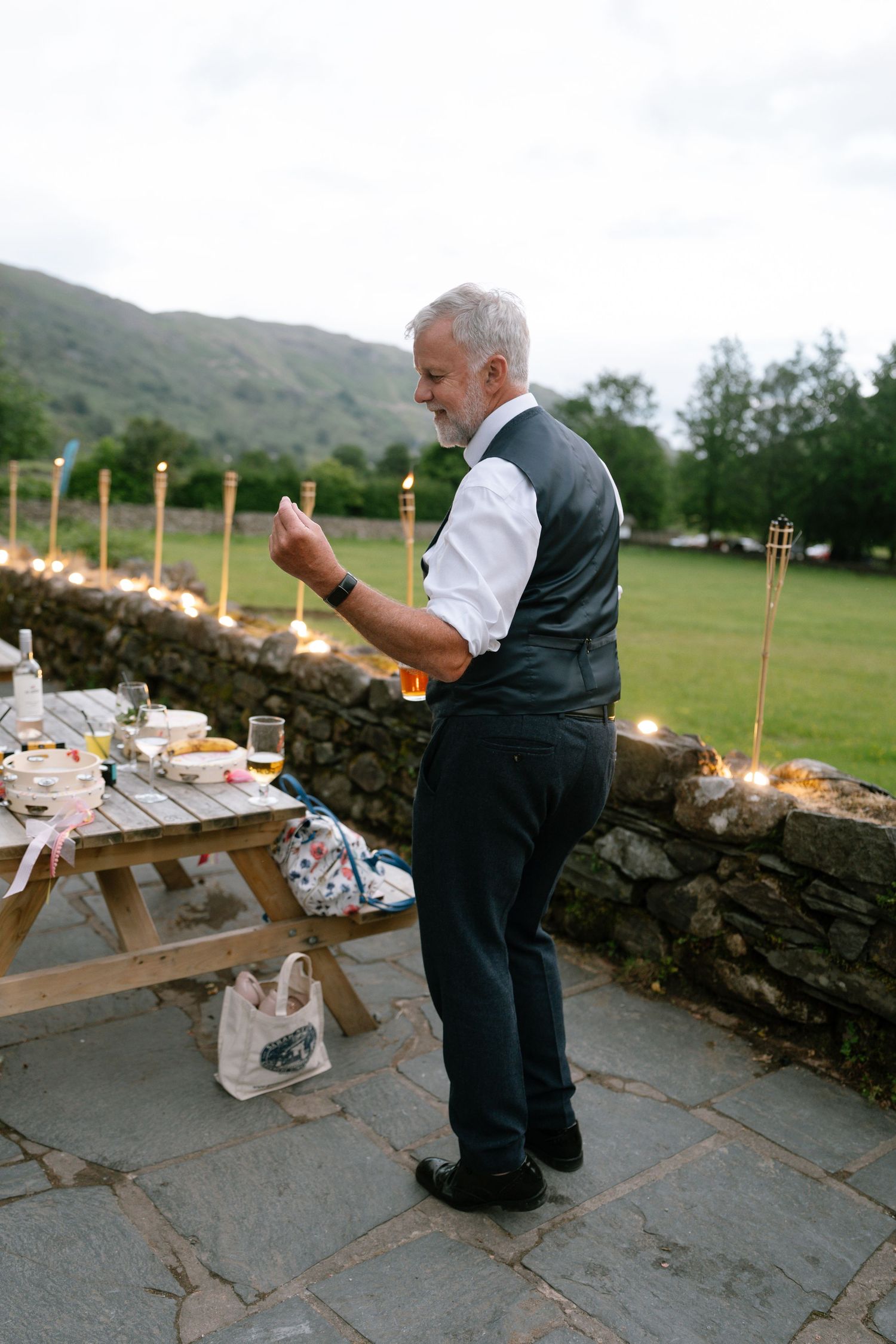 Guest enjoying food and drinks at an outdoor picnic table with mountain views.