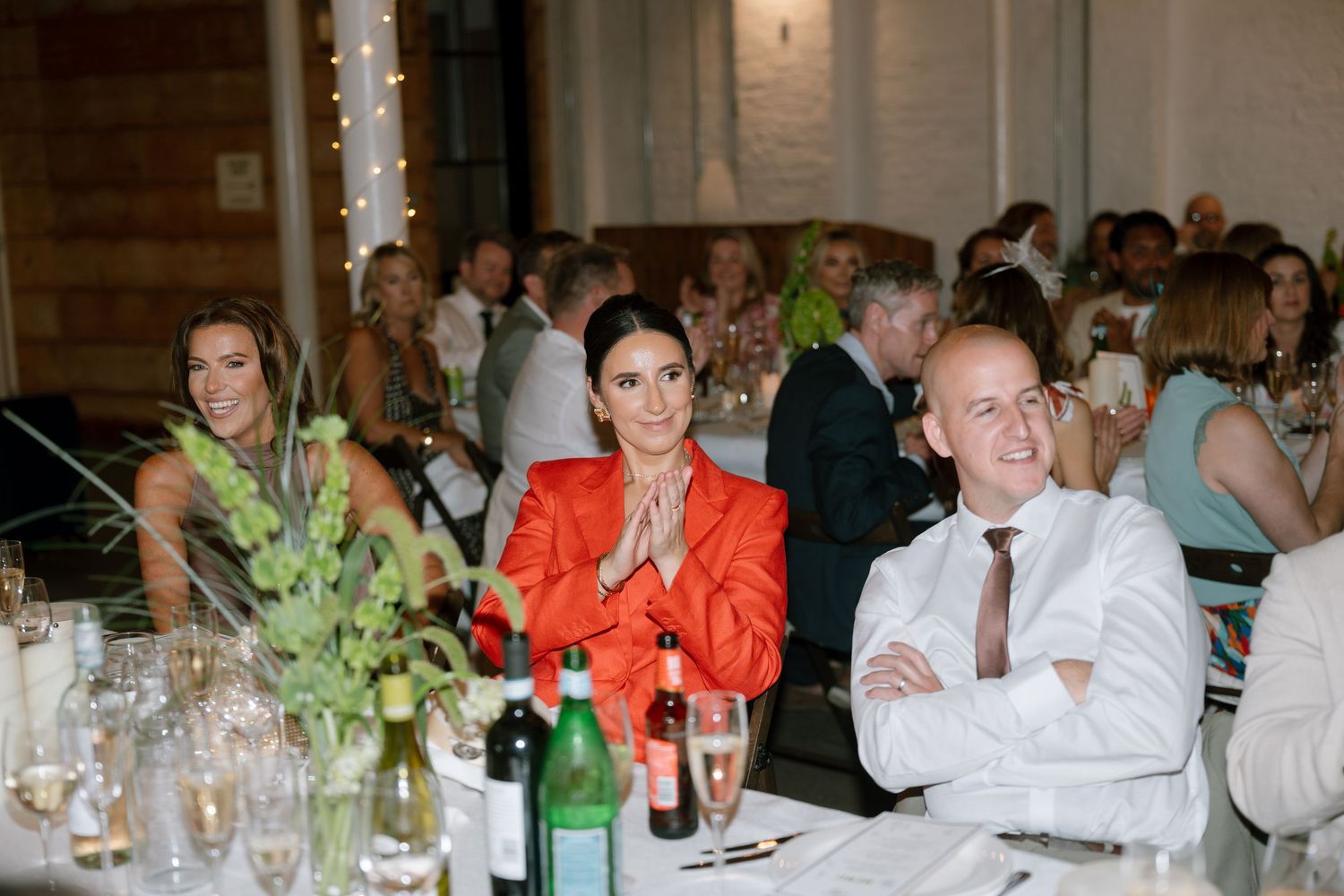 Wedding reception dinner setup with elegant table settings and ambient lighting.