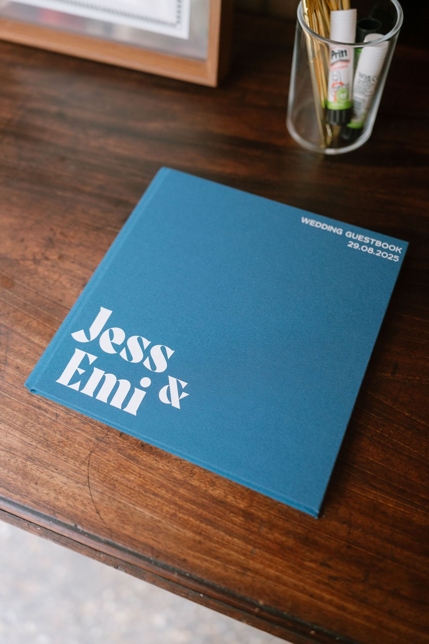 Modern blue wedding invitation cards displayed on a wooden surface.