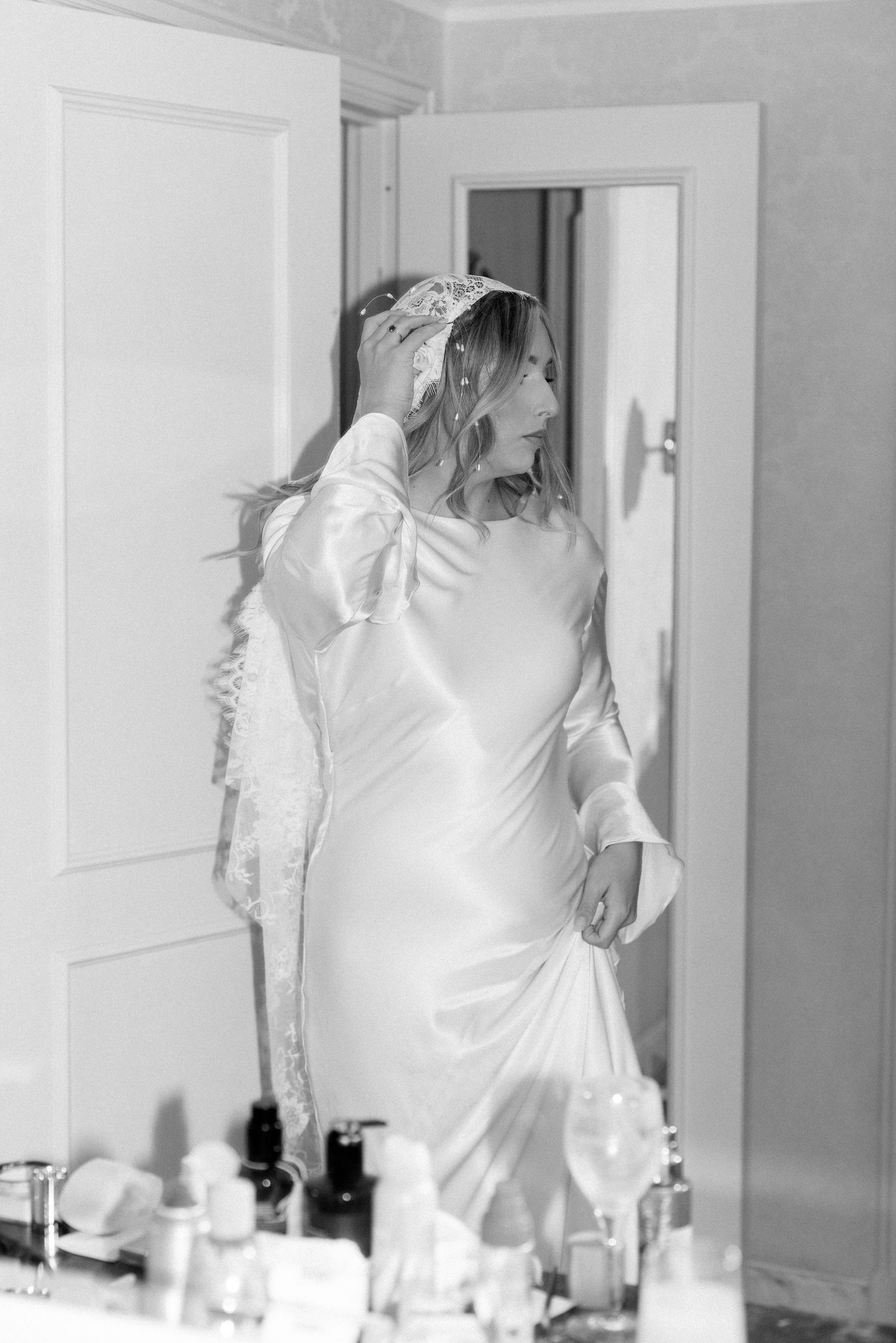 Multiple images showing a figure in white dress moving in front of a mirror and doorway.