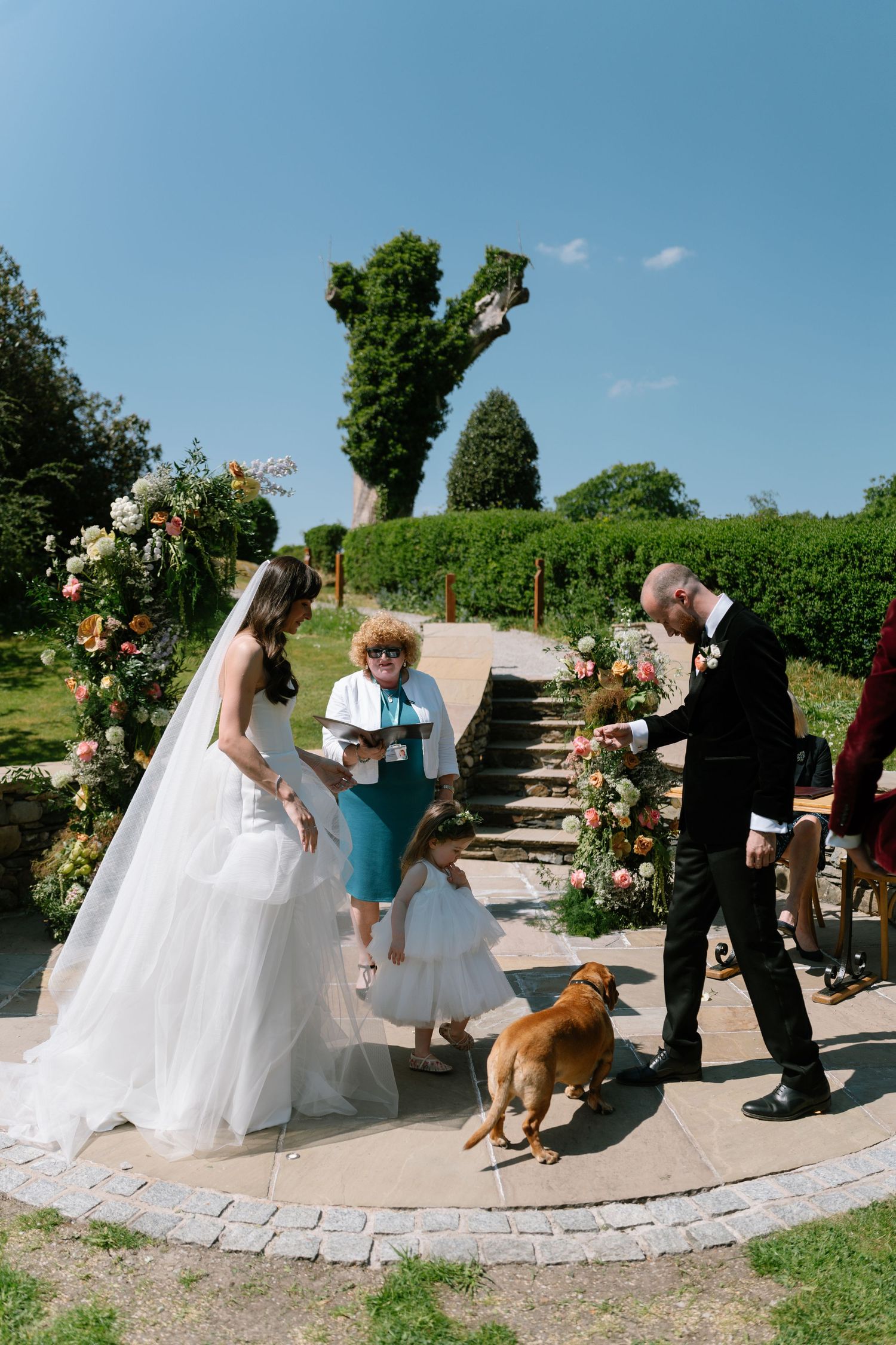 Wedding celebration on stone patio with dog watching the festivities.