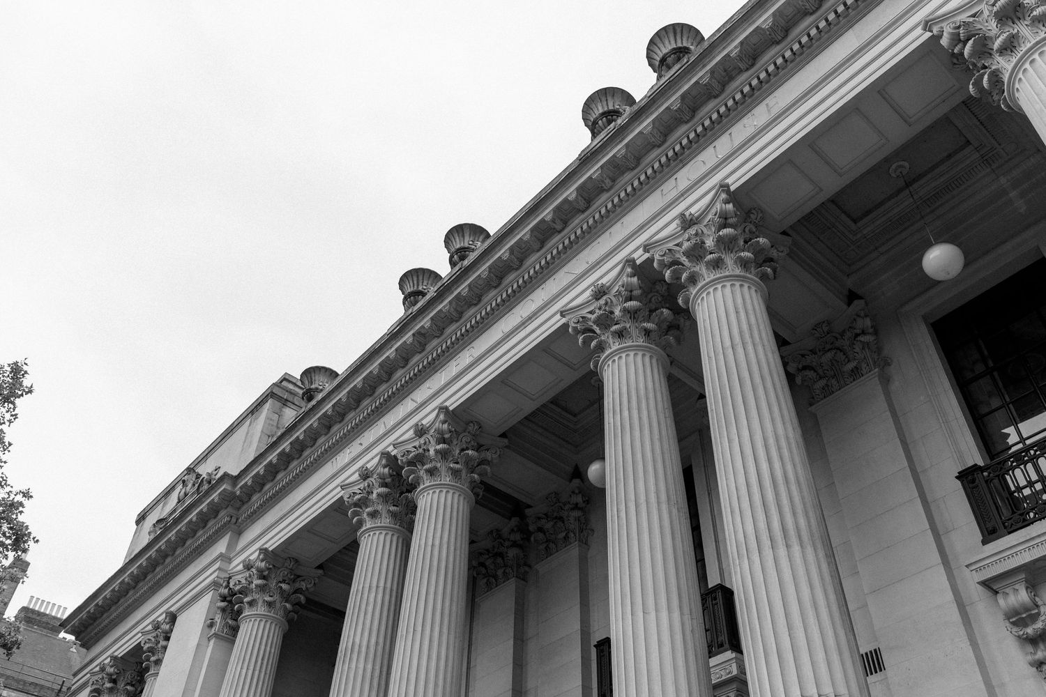 A majestic row of white Corinthian columns adorns the facade of a grand classical building in daylight.