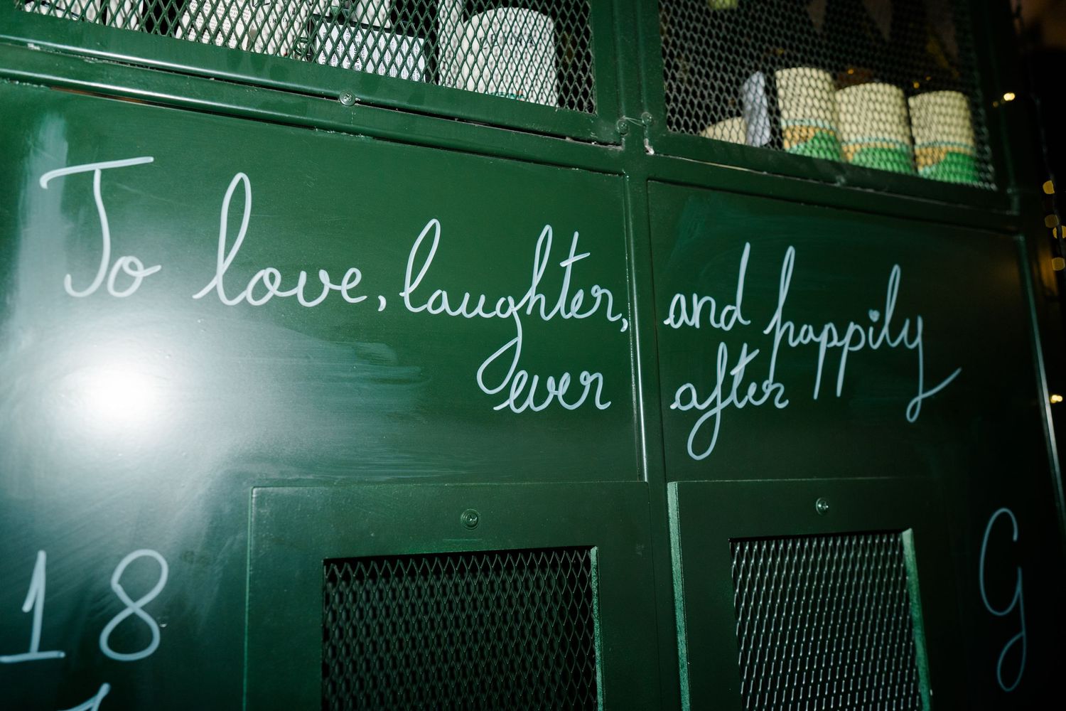 Chalkboard sign reading To love laughter and happily ever after in white cursive writing.