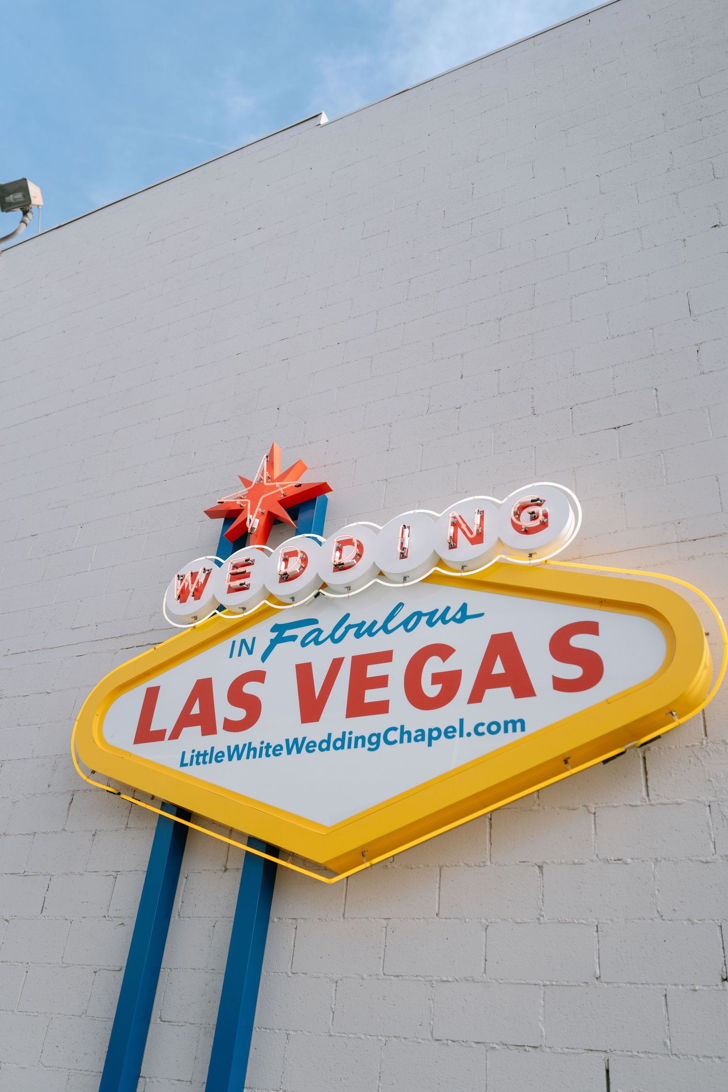 Famous Las Vegas welcome sign styled for weddings with yellow and red neon lights.
